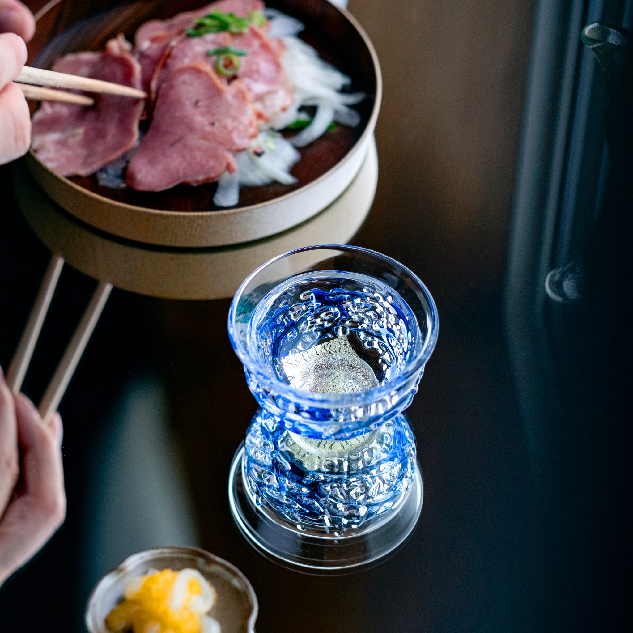 津軽びいどろ 盃12ヶ月コレクション 3月春雷 料理と並んでいる盃の画像