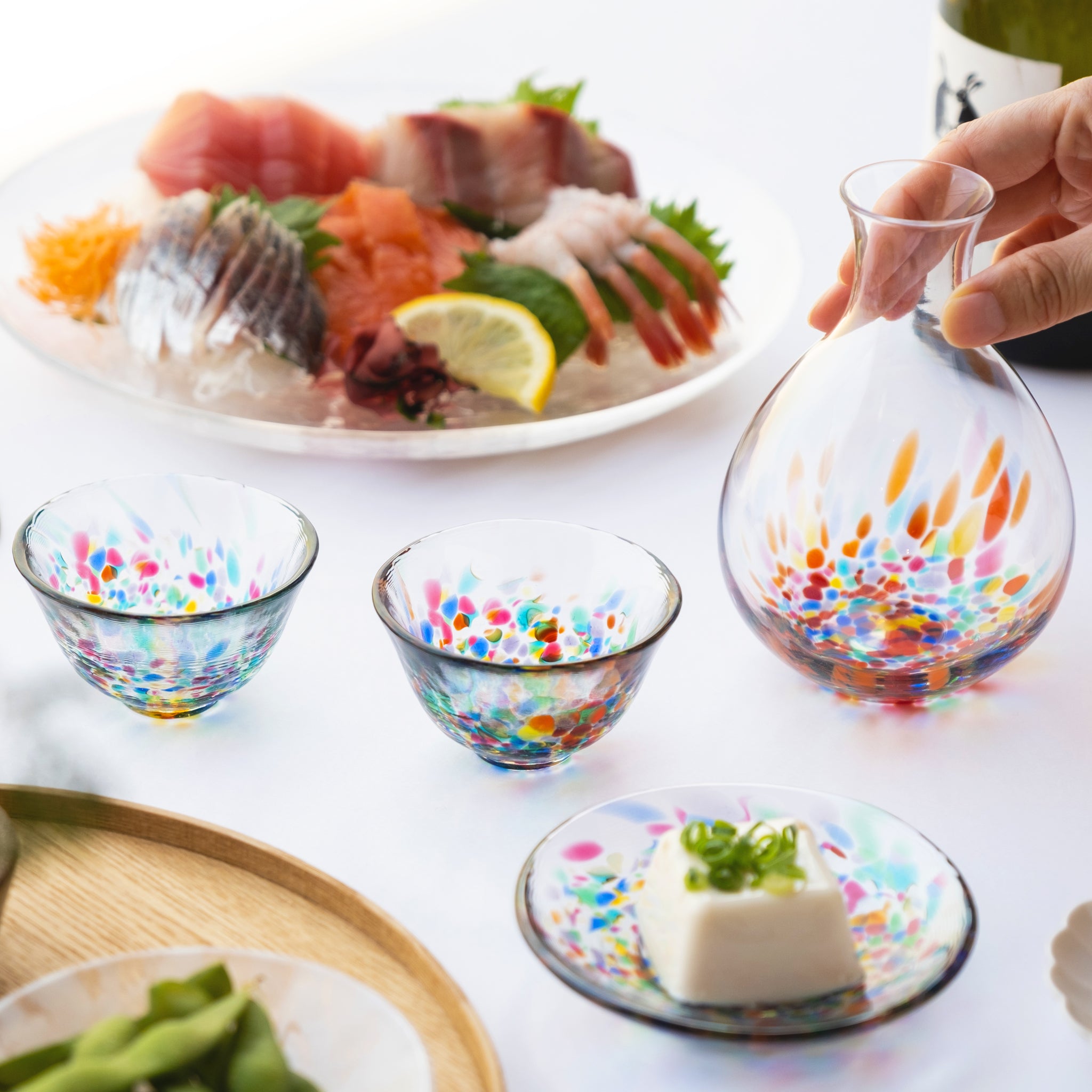 津軽びいどろ 酒器 ねぶた流し酒器セット 徳利を手で持っている画像