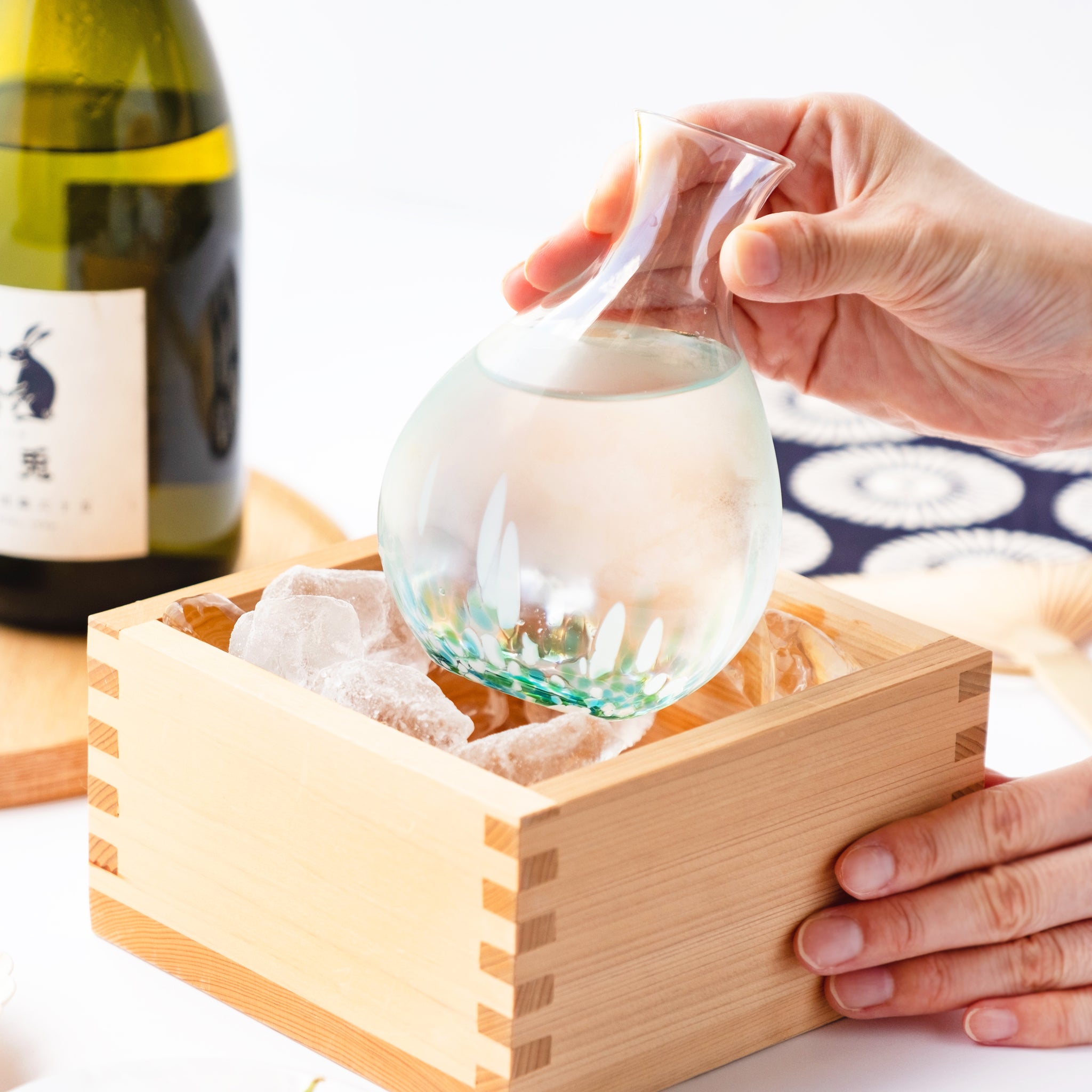 津軽びいどろ 酒器 みずばしょう酒器セット 徳利を手で持ち上げている画像