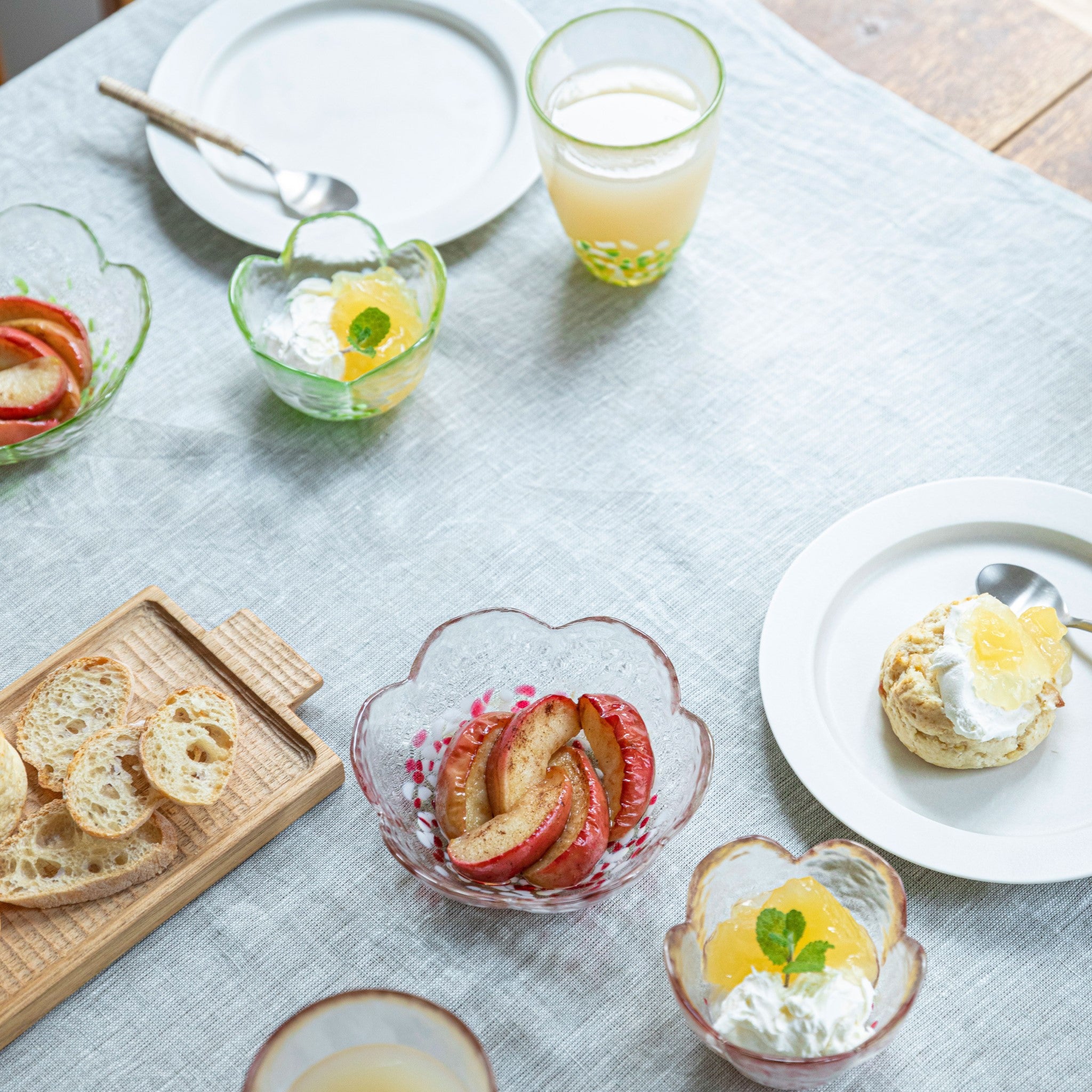 津軽びいどろ りんご 小付小鉢セット 食卓にグラスやガラスの器が並んでいる画像