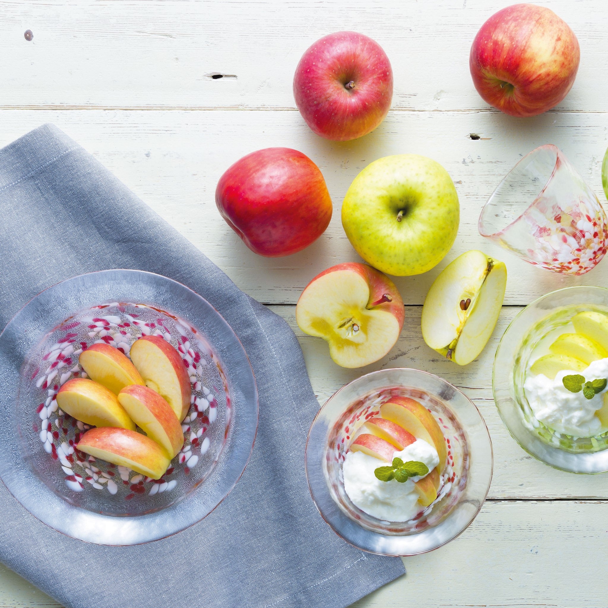 津軽びいどろ 津軽自然色りんご あかりんごディッシュ テーブルにりんごとガラスの器が並んでいる画像