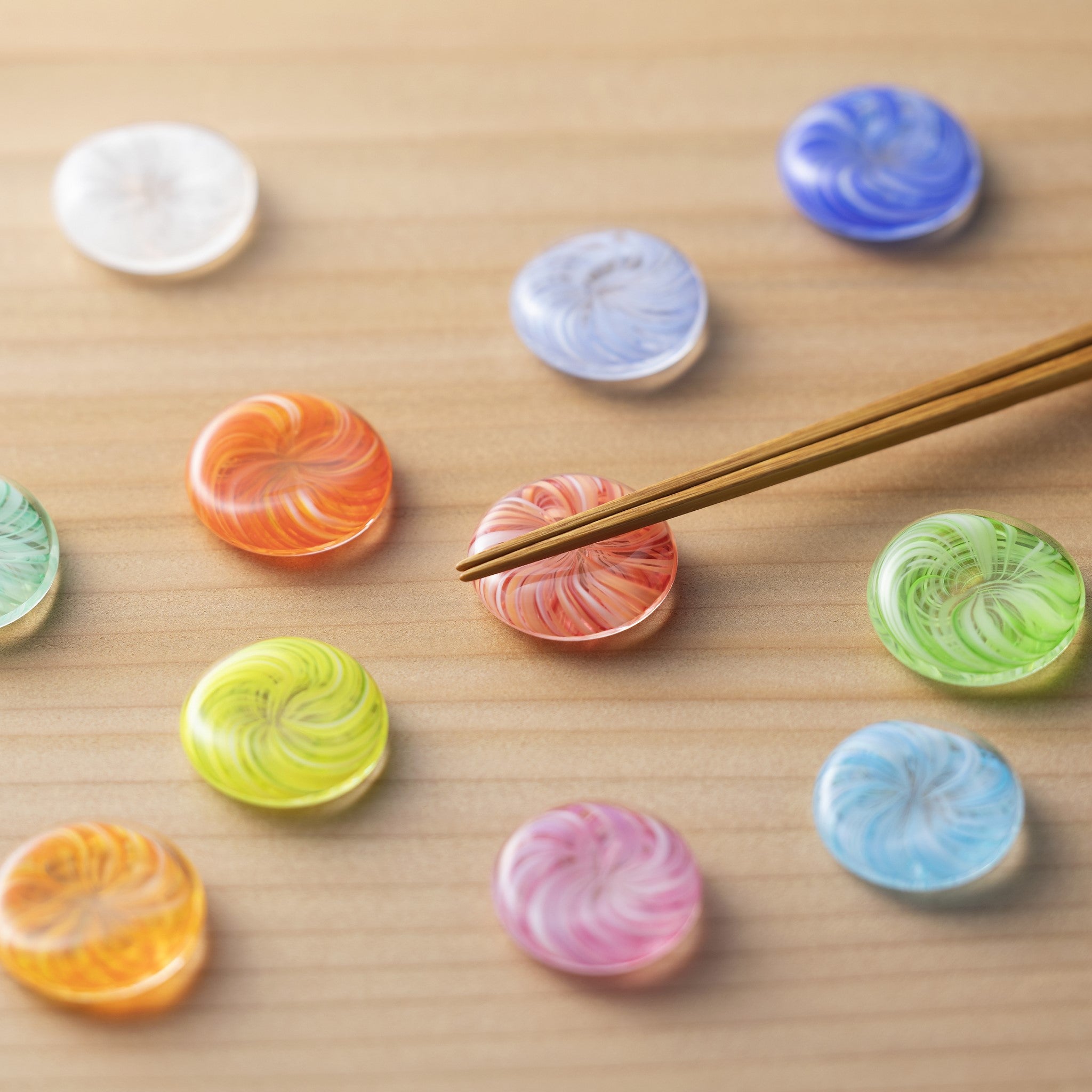 津軽びいどろ 12色の箸置き 白練 テーブルに箸置きがたくさん並んでいる画像