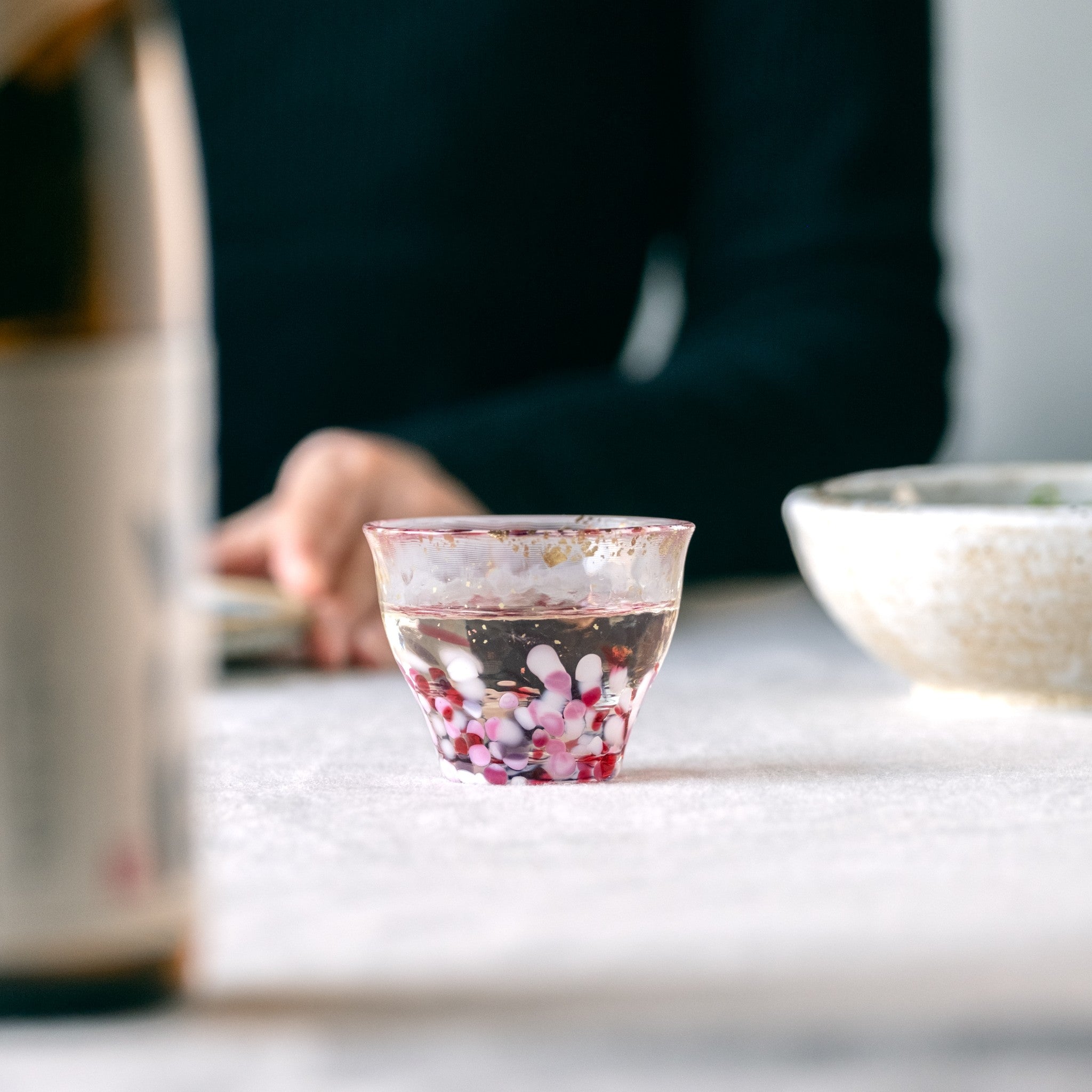 津軽びいどろ 金彩ぐいのみ こぼれ桜 日本酒が注がれたガラスのおちょこ