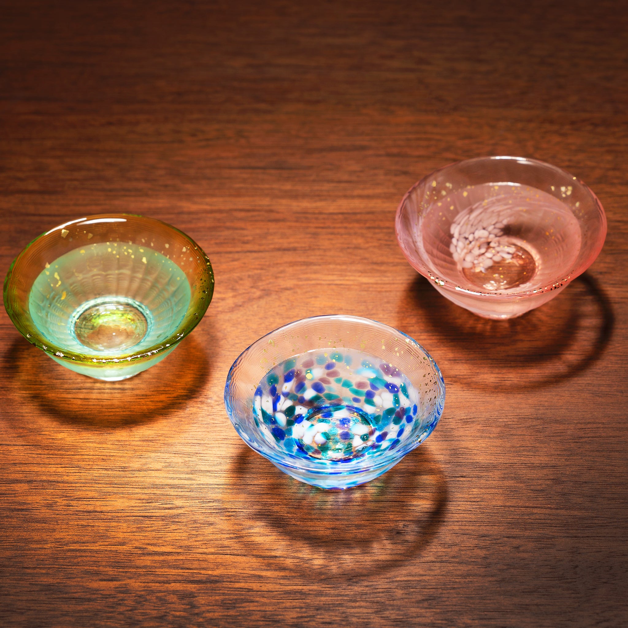 津軽びいどろ 爽華 金彩 盃 花霞 木箱入 色違いの盃がテーブルに並んでいる画像