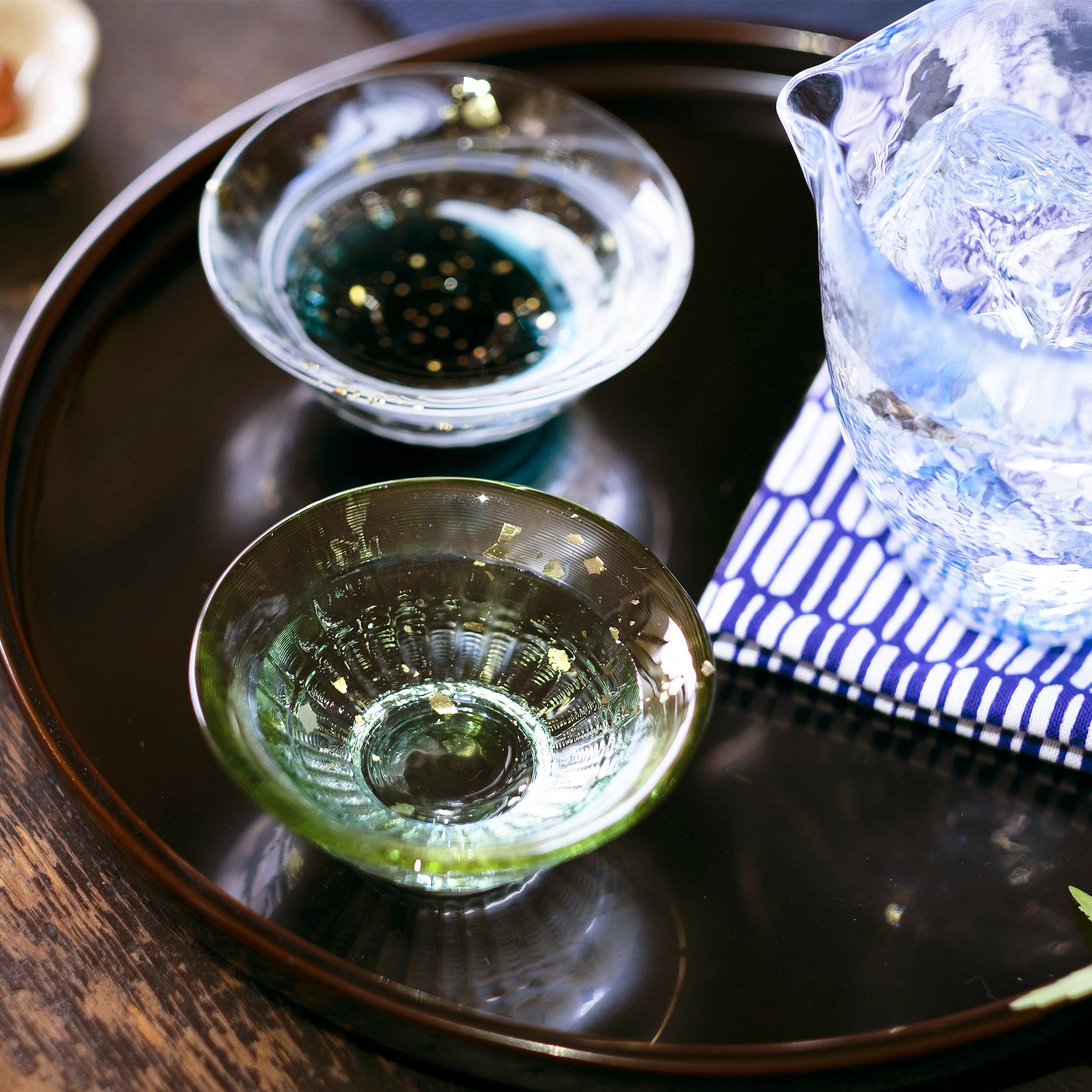 津軽びいどろ 爽華 金彩 盃 月明 木箱入 日本酒が注がれた色違いの盃がお盆に並んでいる画像