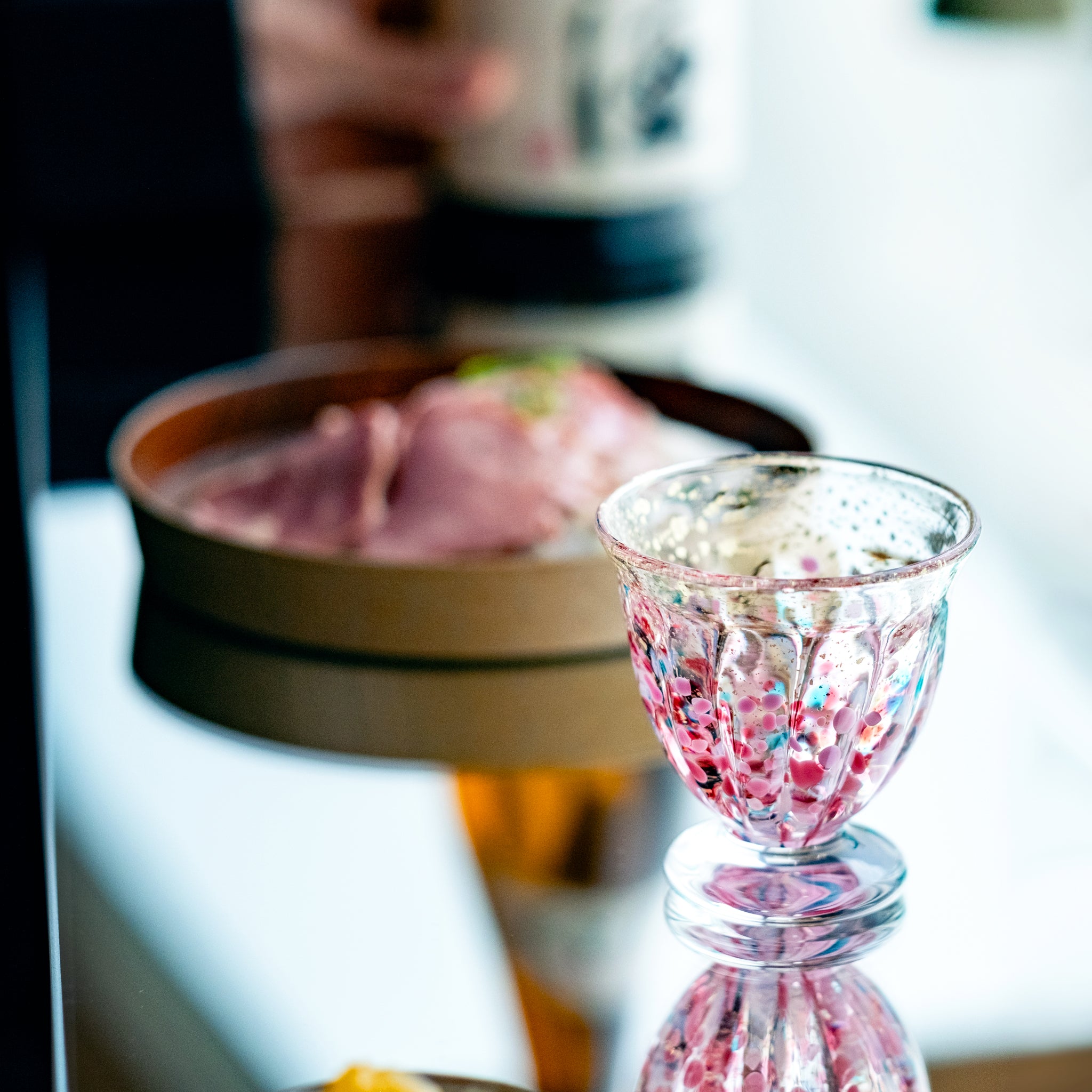 津軽びいどろ 盃12ヶ月コレクション 2月春時雨 料理と日本酒と並んでいる盃の画像