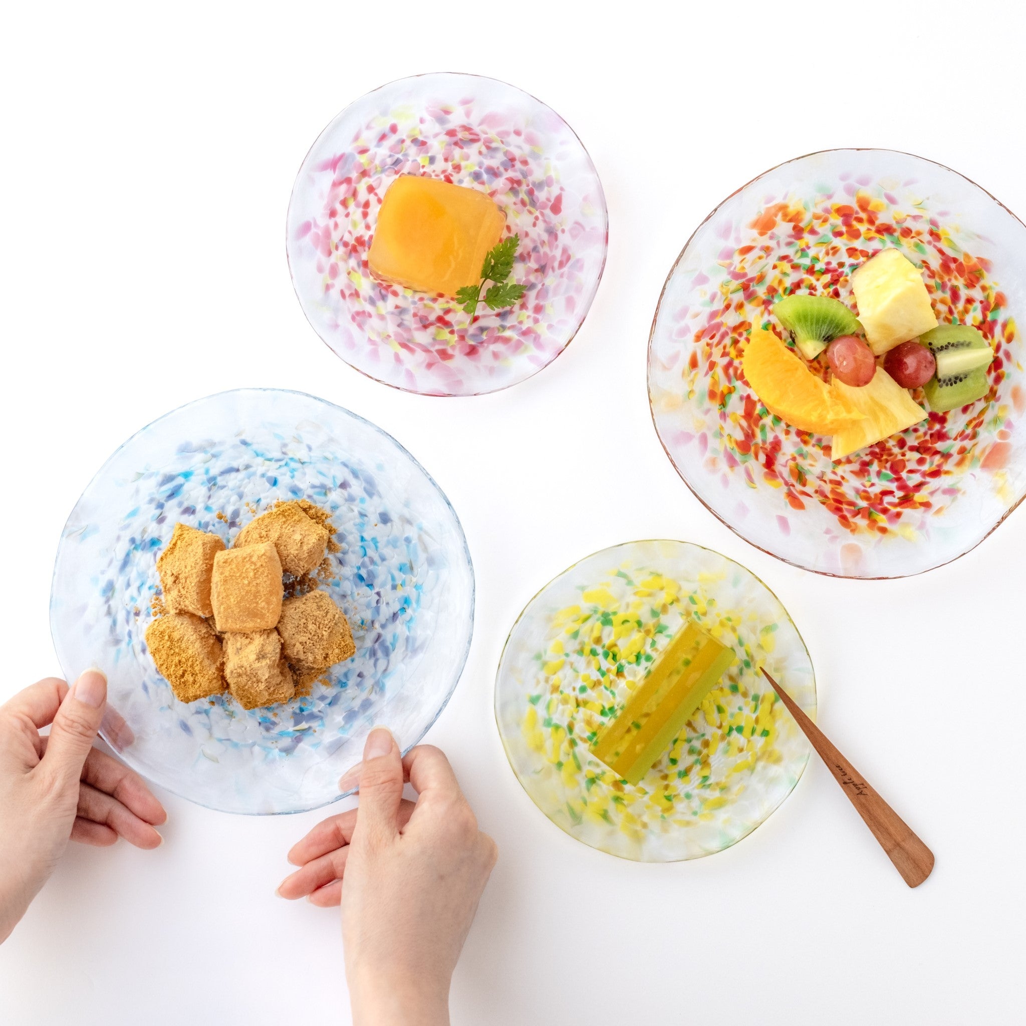 津軽びいどろオンラインショップ 津軽びいどろ にほんの色 ふうけい 皿 雪の灯 デザートがよそわれたガラス皿がテーブルに並んでいる画像