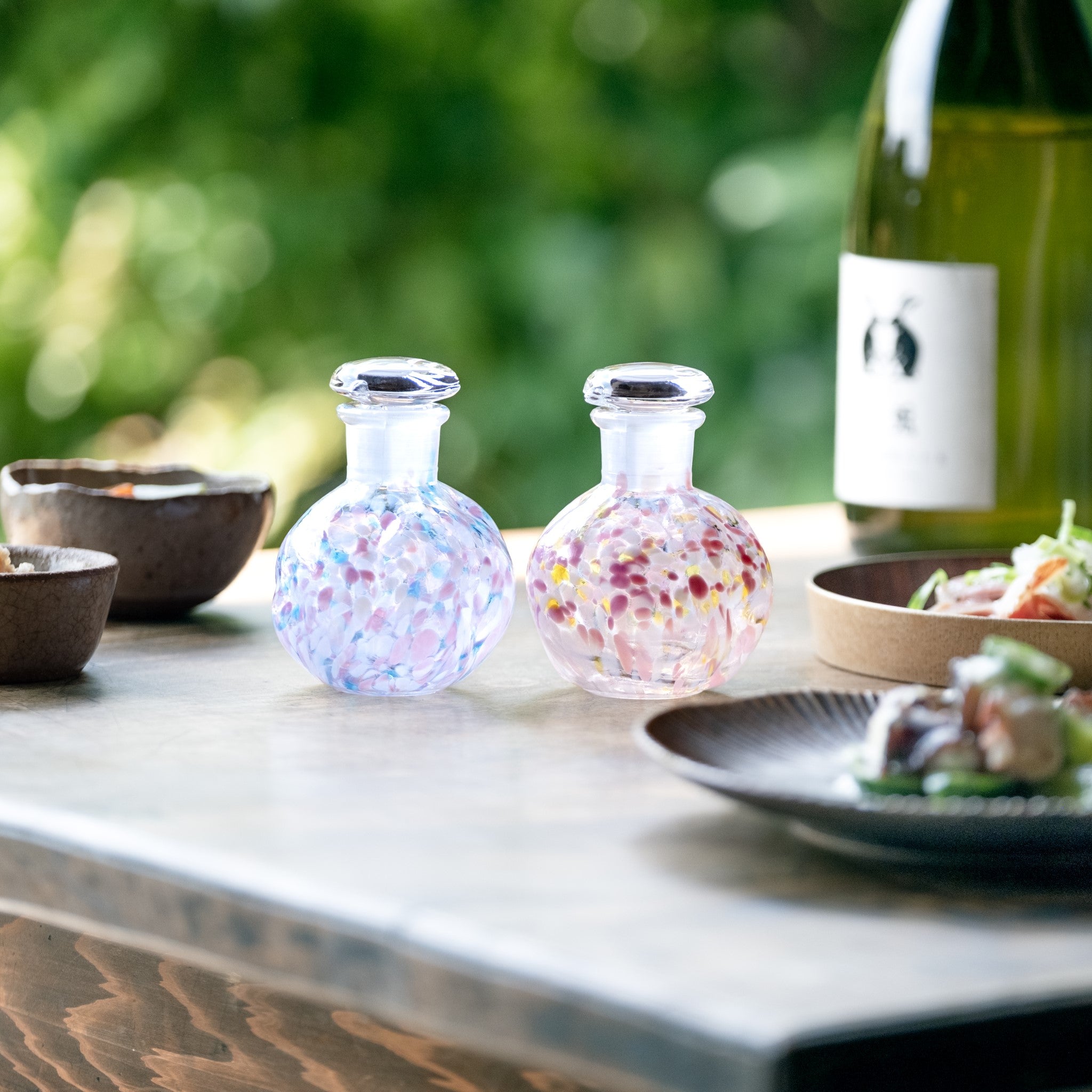 津軽びいどろ さくらさくら 桜と菜の花 醤油差し 料理がよそわれた皿と並ぶ醤油差しの画像