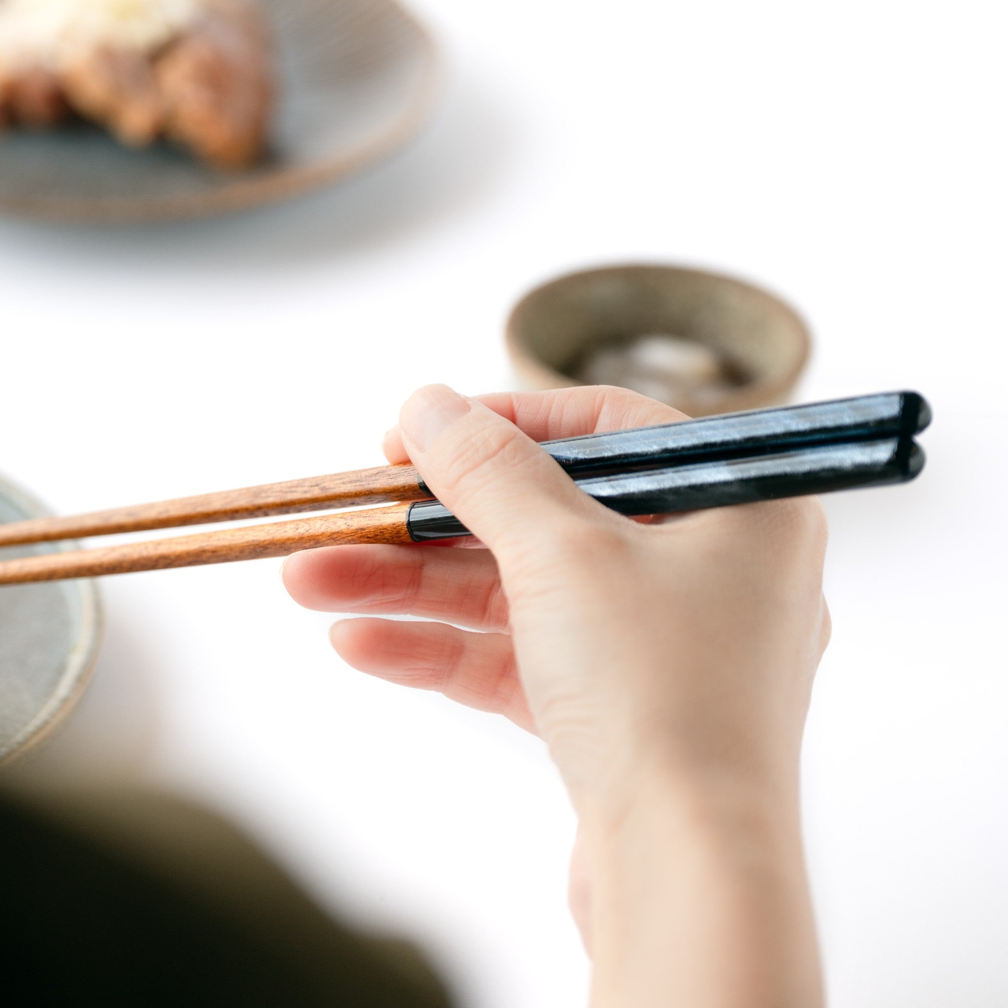 津軽びいどろ NEBUTA ねぶた箸置箸セット 若狭塗の箸を手で持っている画像