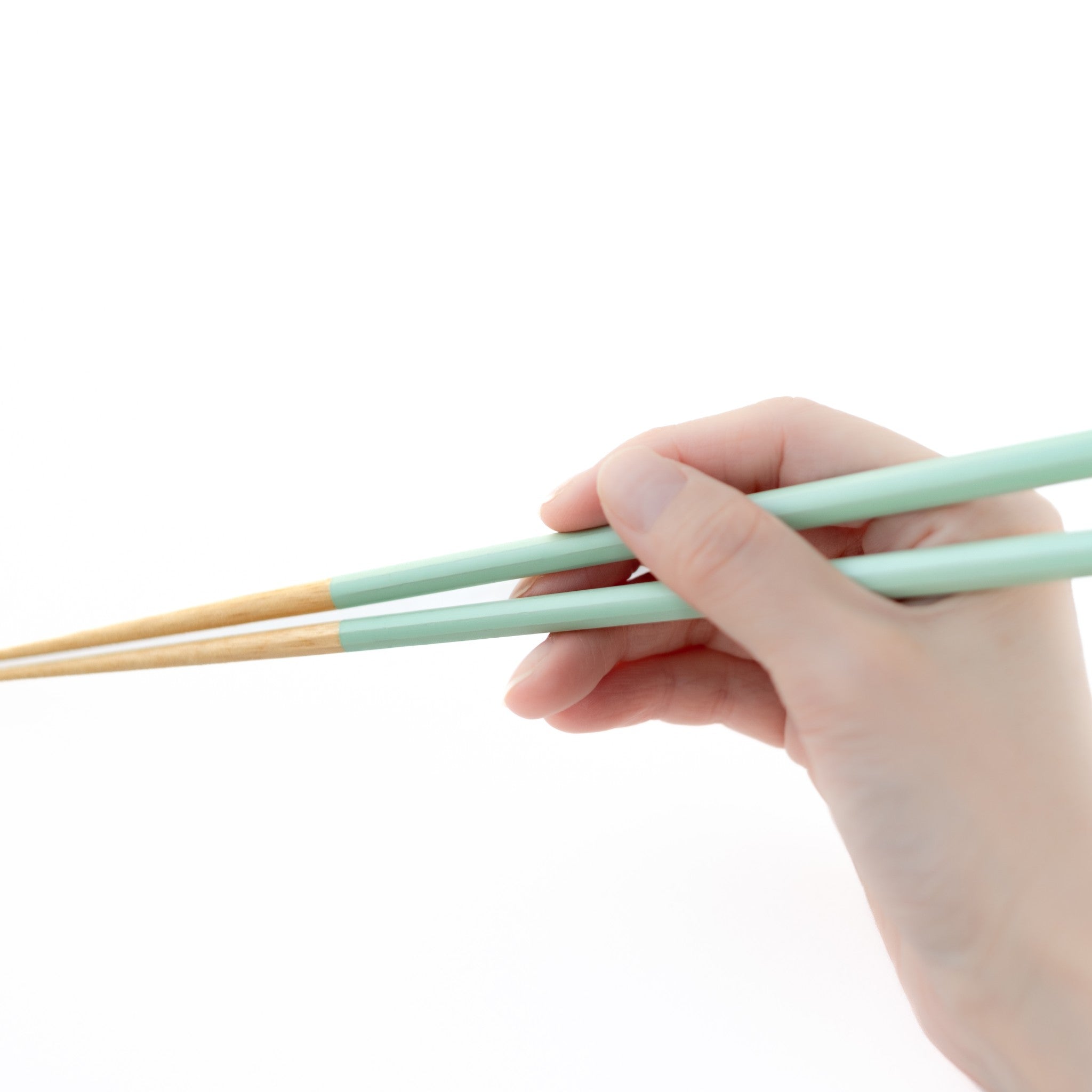 津軽びいどろ 津軽自然色りんご りんご箸置箸セット 若狭塗の箸を手で持っている画像