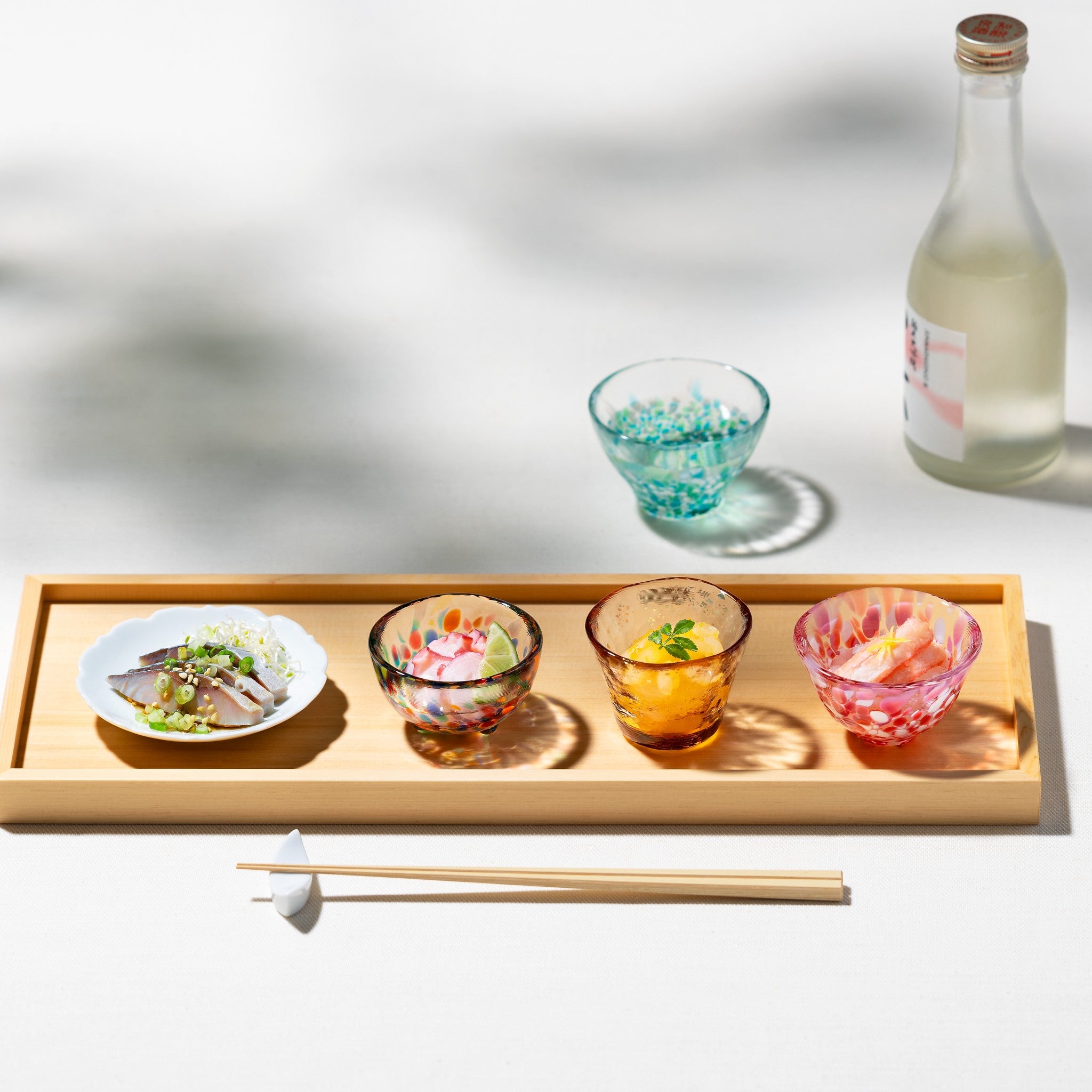 津軽びいどろ 彩ミニグラス 四種揃え ガラスのおちょこに日本酒や副菜を入れている様子