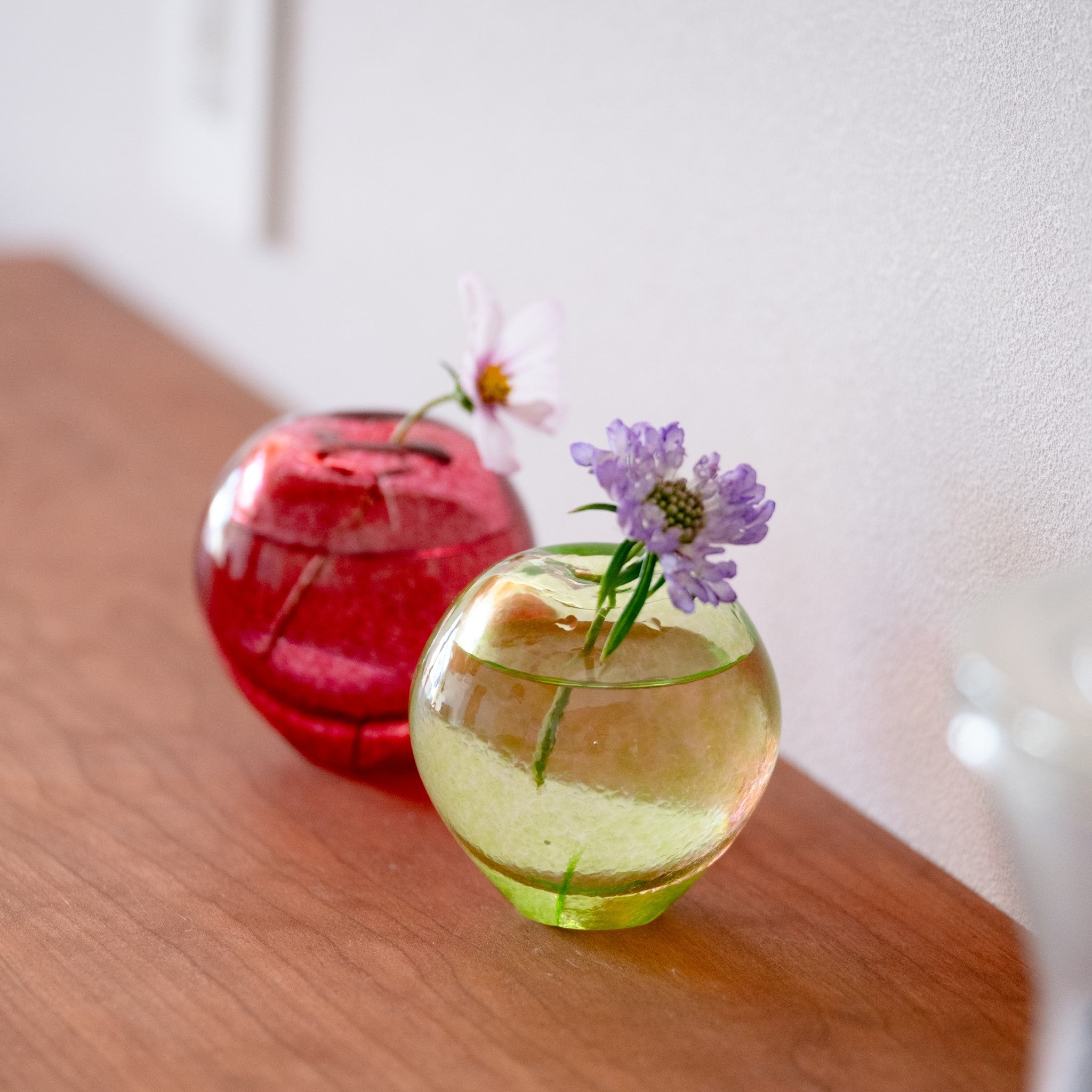 津軽びいどろ 津軽自然色りんご あおりんご一輪挿し りんご型の花瓶に小花が活けられている画像