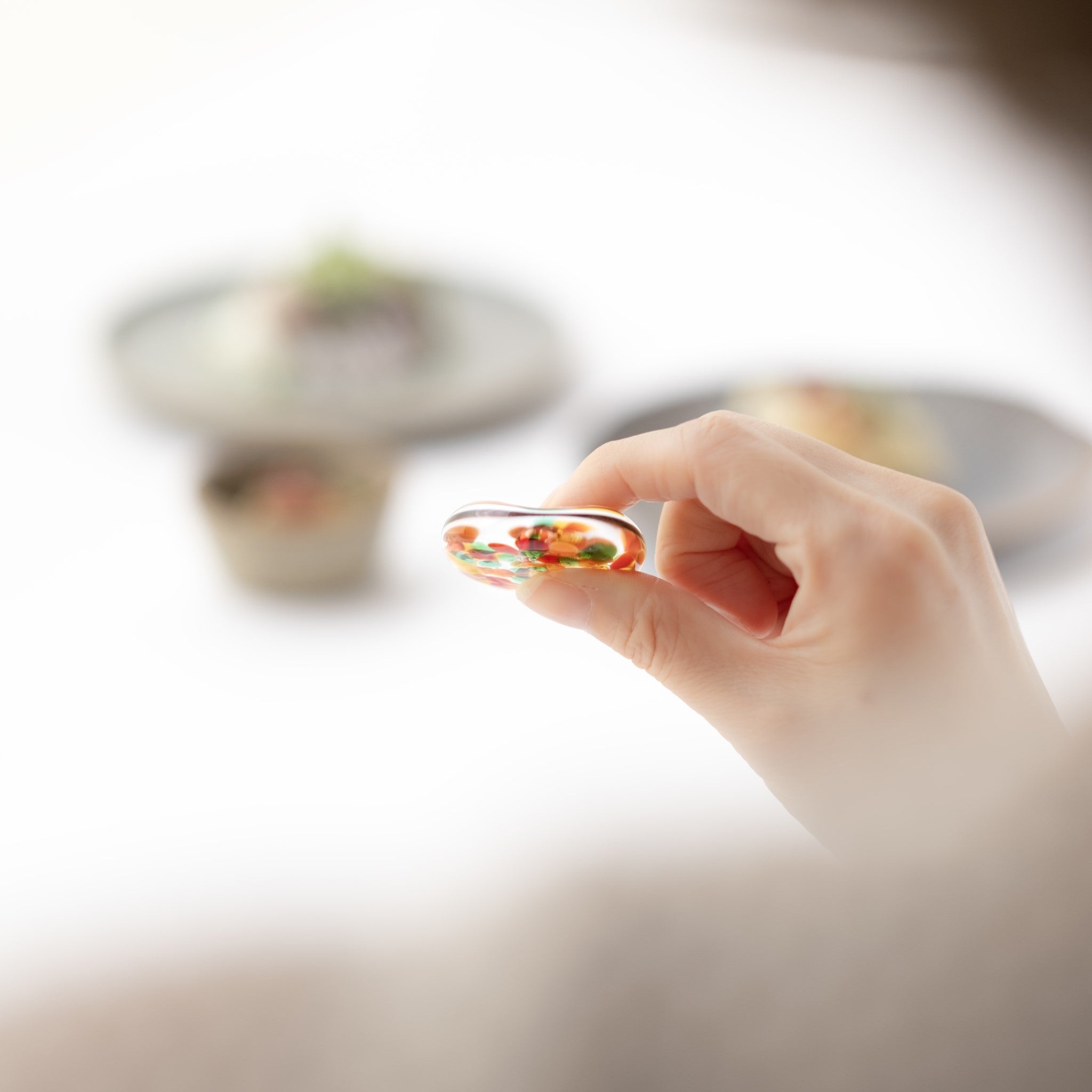 津軽びいどろ ⼗⼆花⽉ 箸置き 6月 バラ 箸置きを手でつまんでいる画像