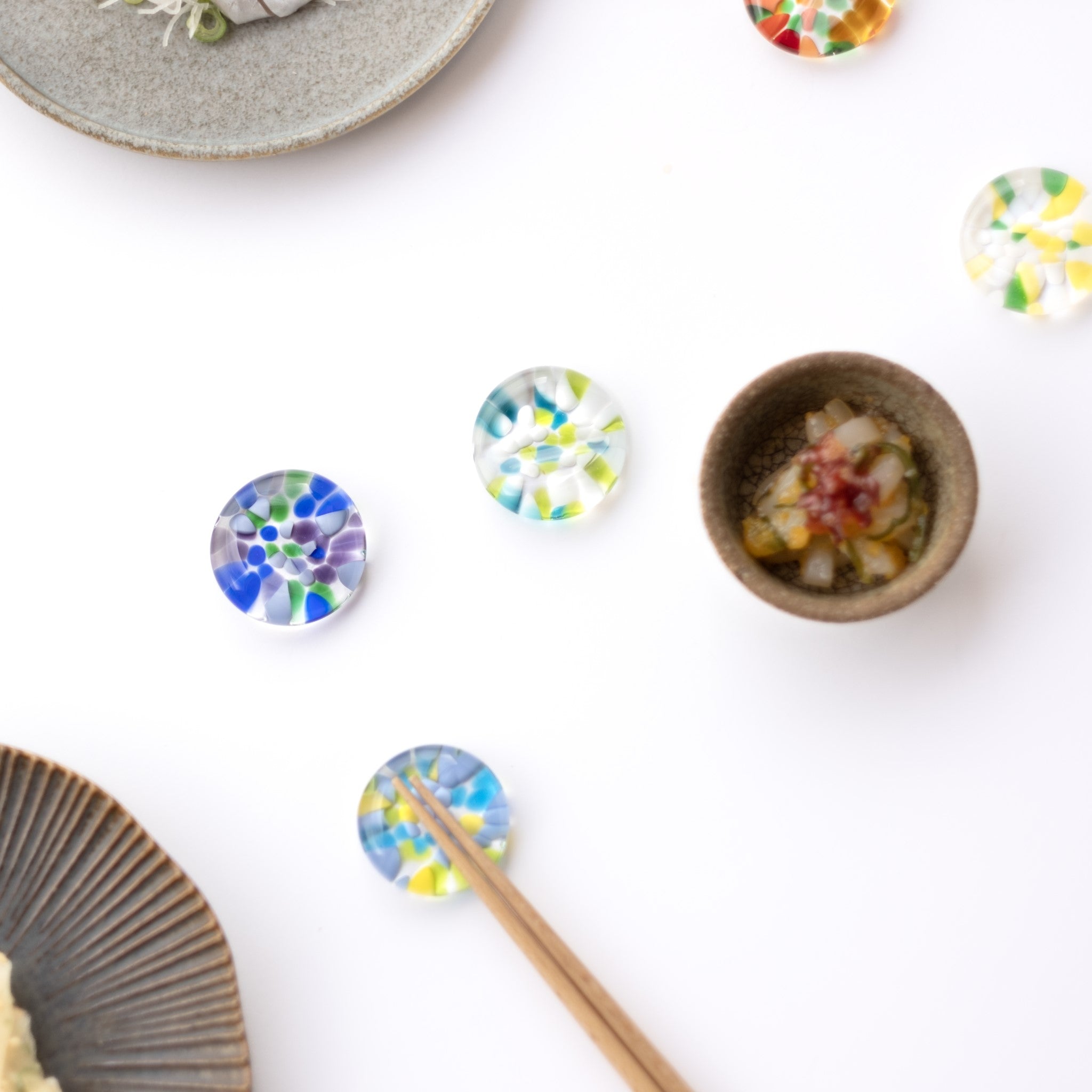 津軽びいどろ ⼗⼆花⽉ 箸置き 9月 リンドウ 色違いの箸置きがテーブルに並んでいる画像