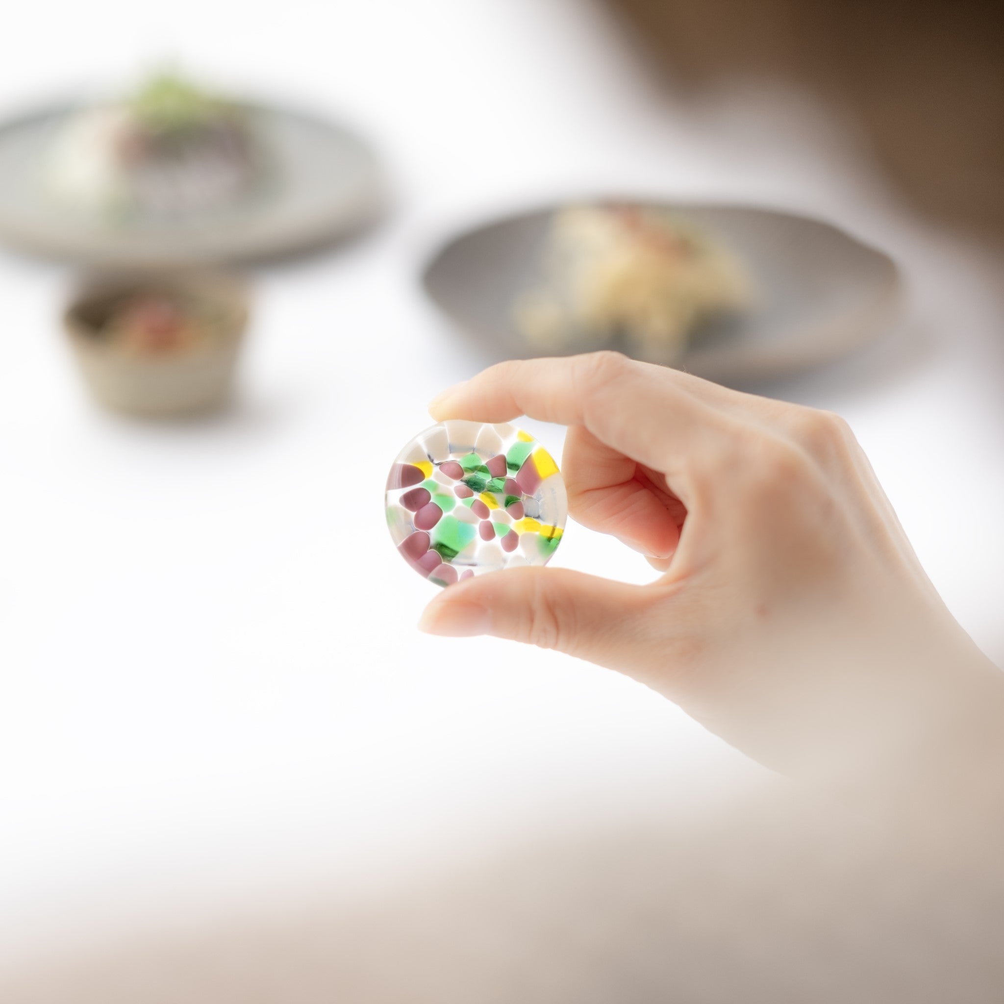 津軽びいどろ ⼗⼆花⽉ 箸置き 11月 シクラメン ガラスの箸置きを手でつまんでいる画像