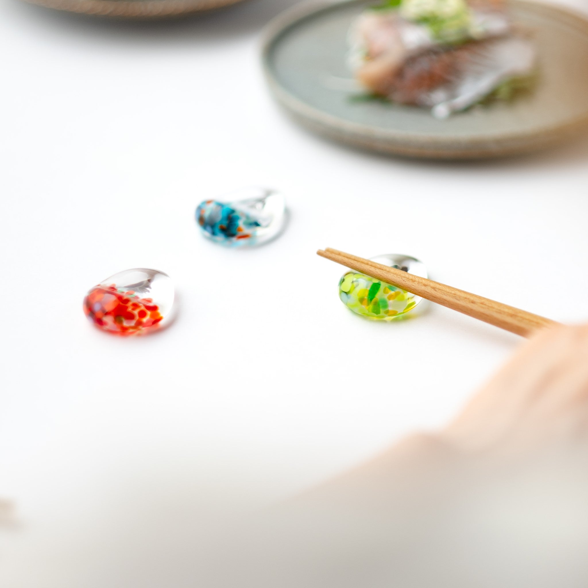 津軽びいどろ 白神の森響 箸置き ブナの新緑 しずく型の箸置きがテーブルに並んでいる画像