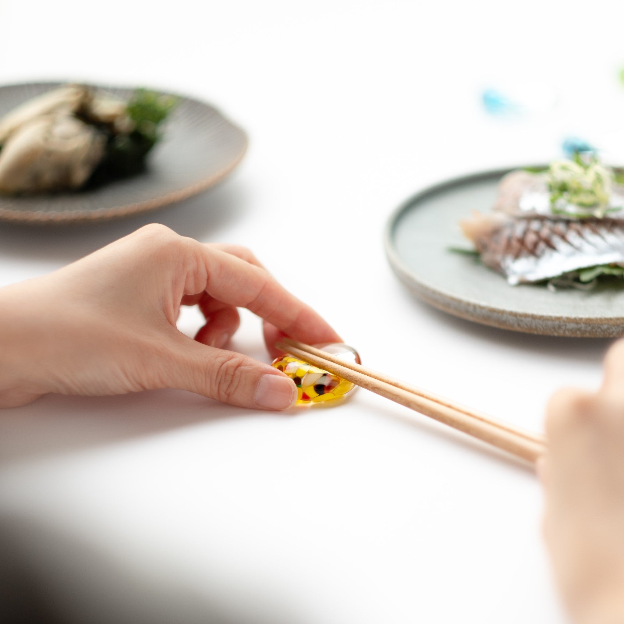 津軽びいどろ 白神の森響 箸置き ブナの⻩葉 食卓に置かれた黄色の箸置きの画像