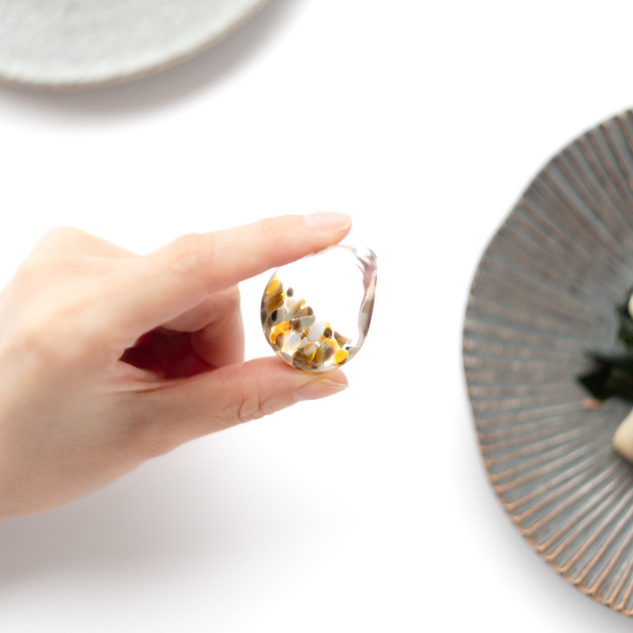 津軽びいどろ 白神の森響 箸置き ニホンカモシカ しずく型の箸置きを手でつかんでいる画像