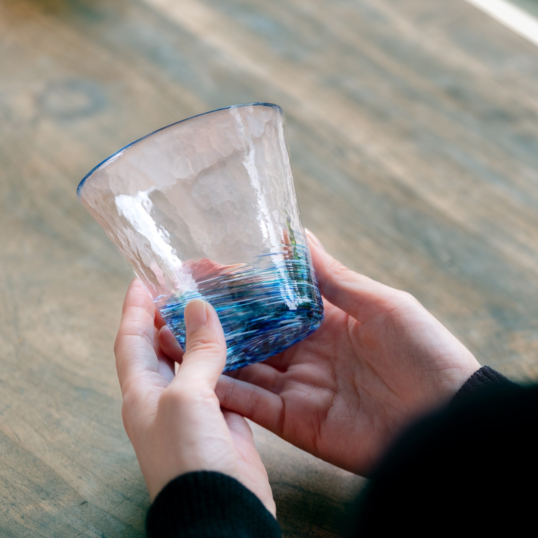 津軽びいどろ 六の色(むつのいろ) グラス 海 グラスを両手で持っている画像