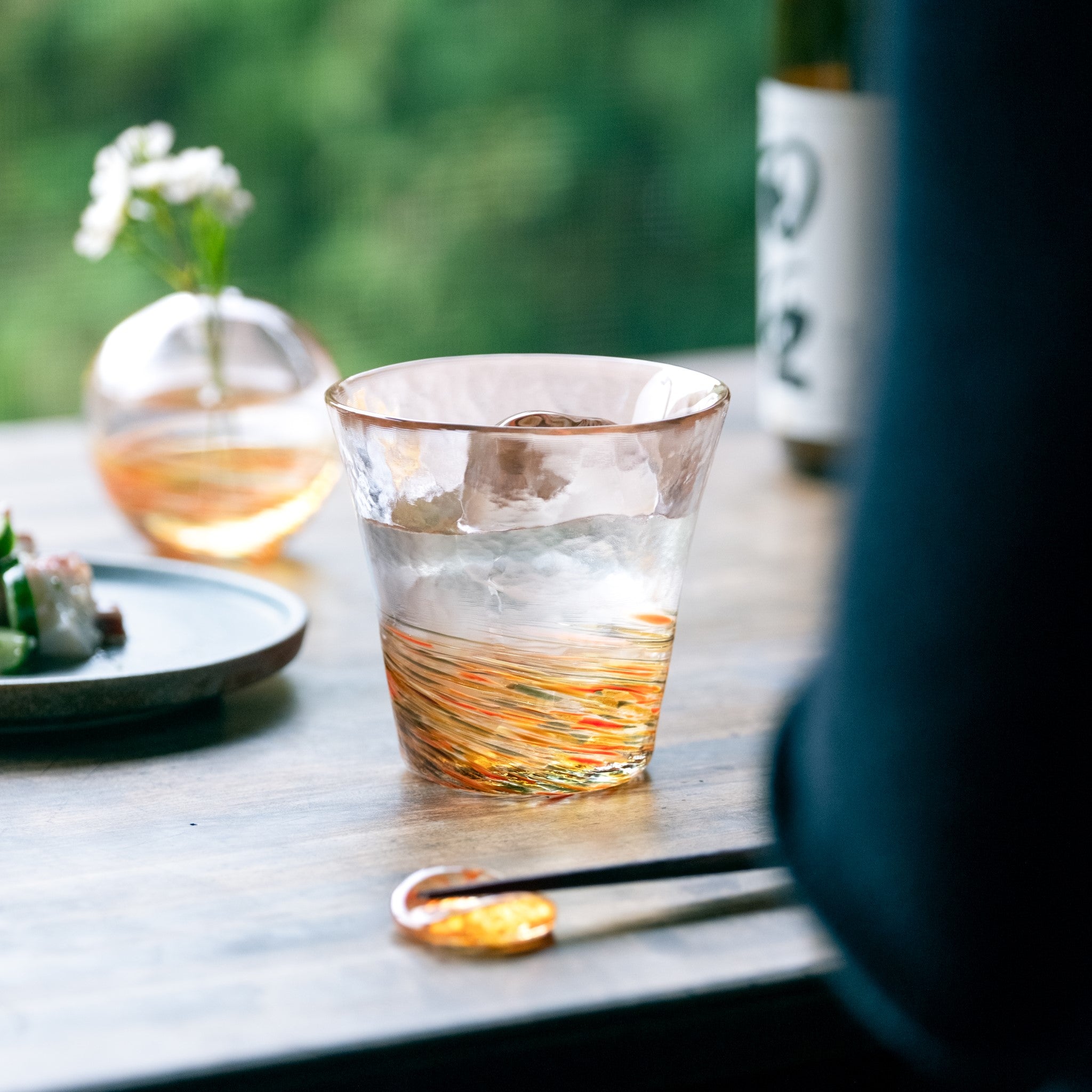 津軽びいどろ 六の色(むつのいろ) 一輪挿し 山 オレンジ色のグラスや花瓶がテーブルに並んでいる画像