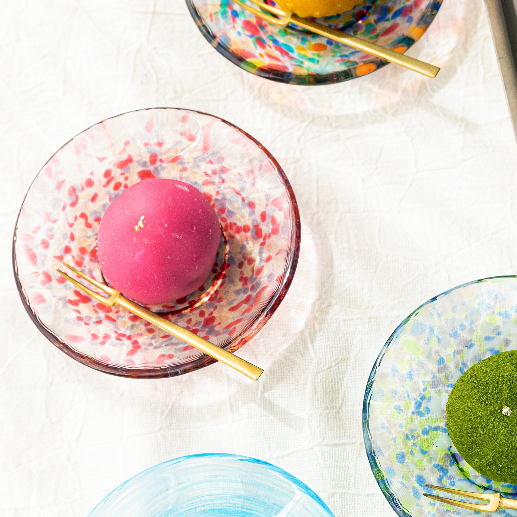 津軽びいどろ 色色豆皿 春茜 和菓子が乗った色違いの小皿の画像