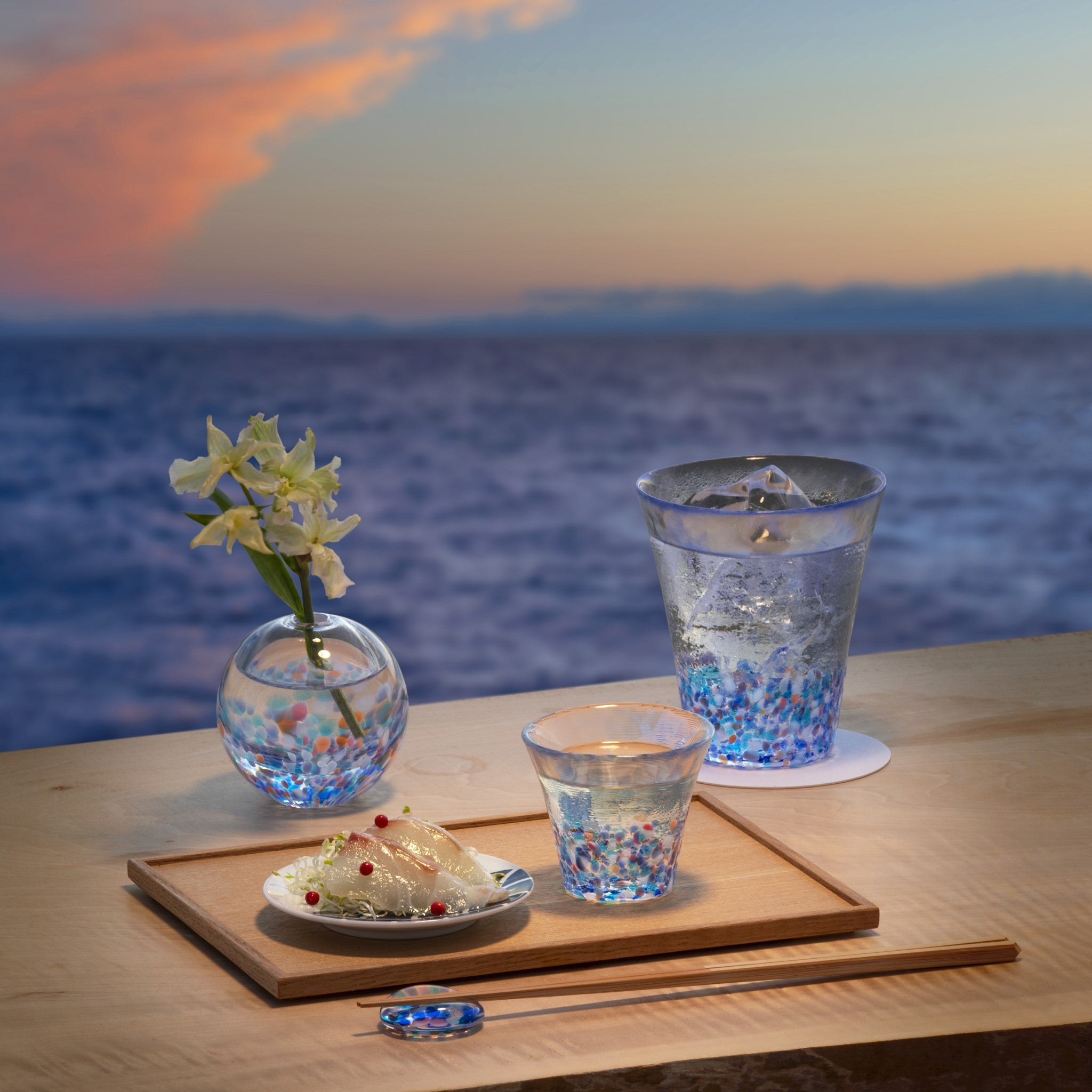 津軽びいどろ にほんの色 ふうけい 盃 夕凪の空 食卓にグラスやおちょこなどガラス食器が並んでいる画像