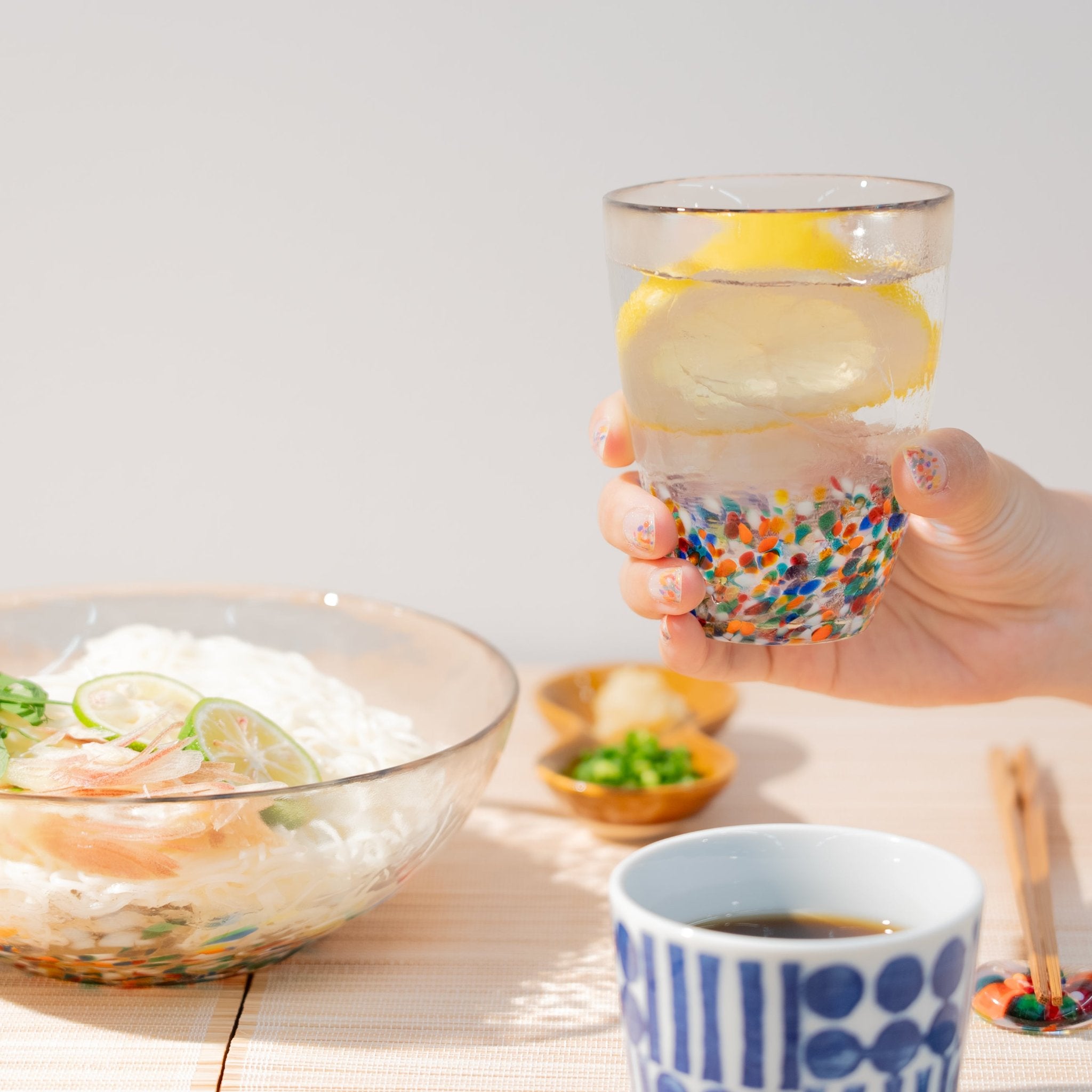 津軽びいどろ NEBUTA ねぶた ネイルシール ネイルシールを着用した手でグラスを持ち上げている画像