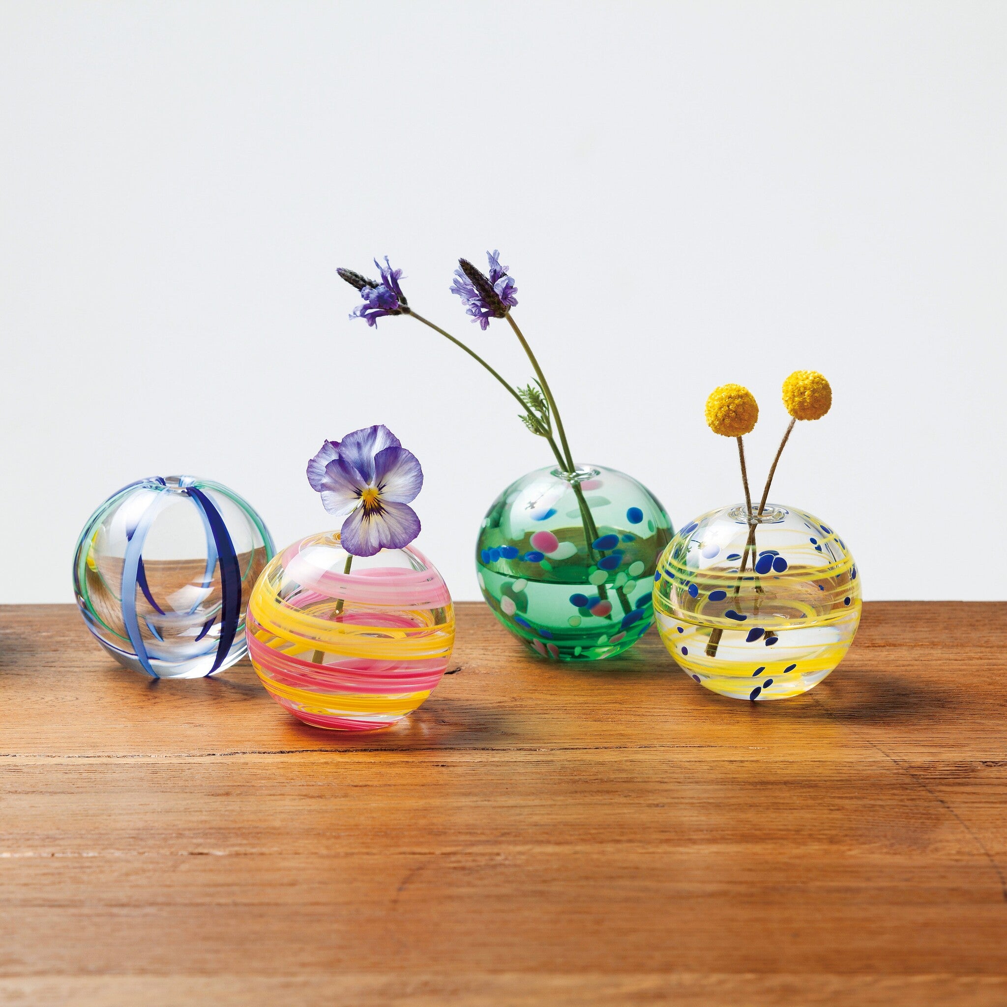 津軽びいどろ 彩手鞠 青葉 一輪挿し 同じシリーズの花瓶がテーブルに並んでいる画像