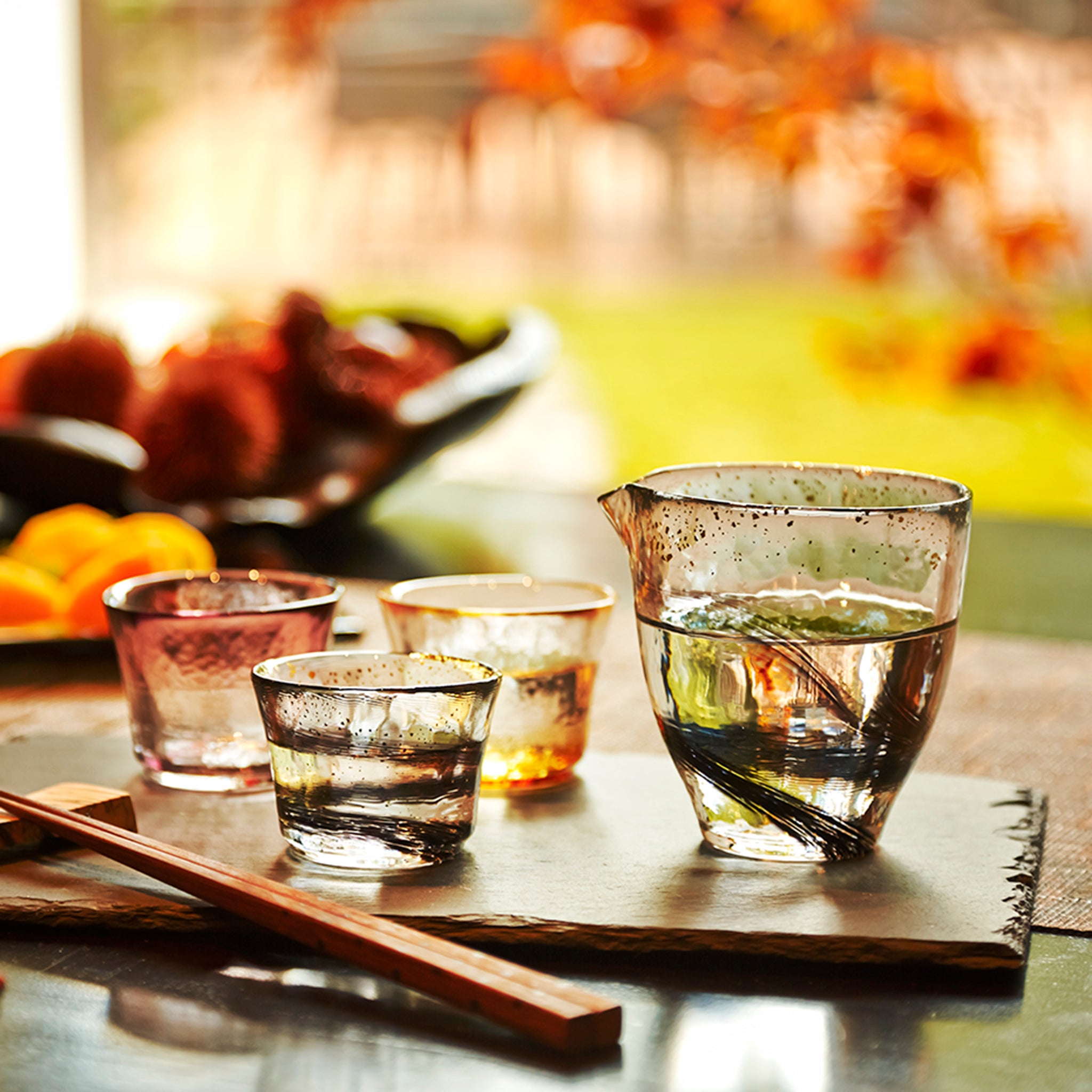 津軽びいどろ 盃コレクション 片口夜風 片口と色違いの盃がテーブルに並んでいる画像