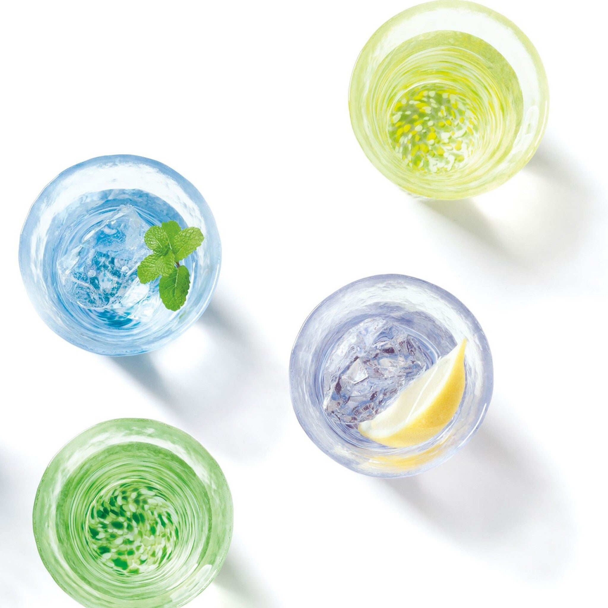 津軽びいどろ 12色のグラス 藤 テーブルに並んでいる色違いのグラスを上から見た画像