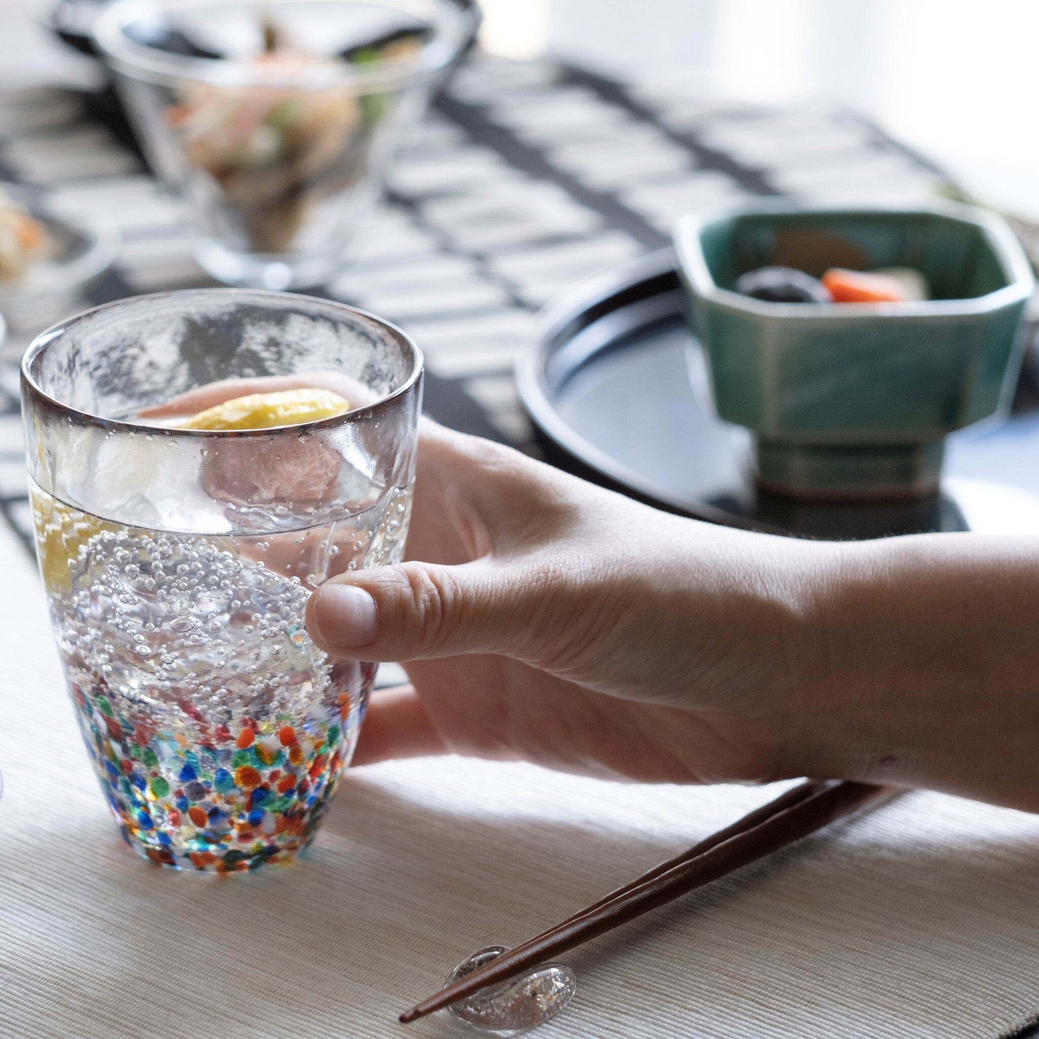 津軽びいどろ NEBUTA ねぶたタンブラーペア 飲み物の入ったグラスを手で持っている画像