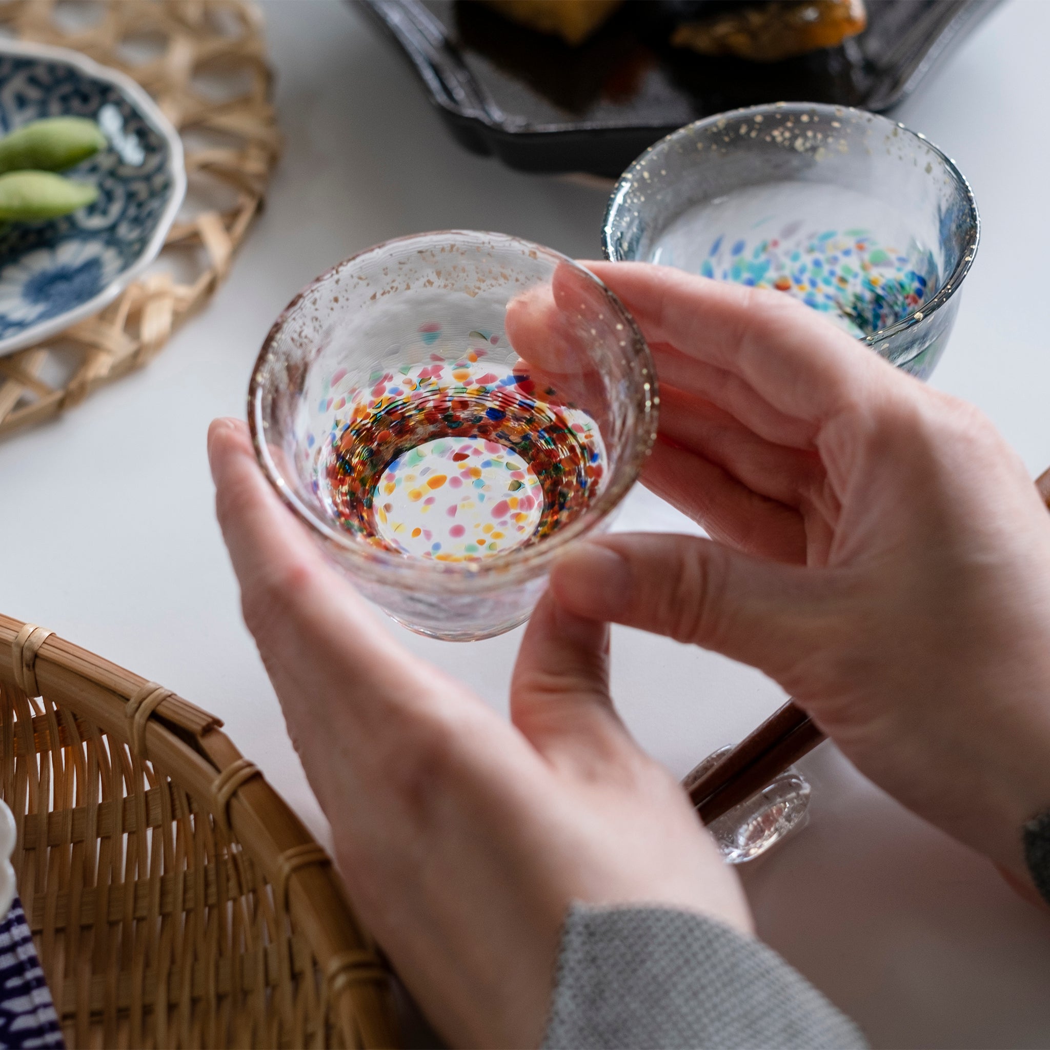 津軽びいどろ MATSURI 金彩ぐいのみペア 盃を両手で持ち上げている画像