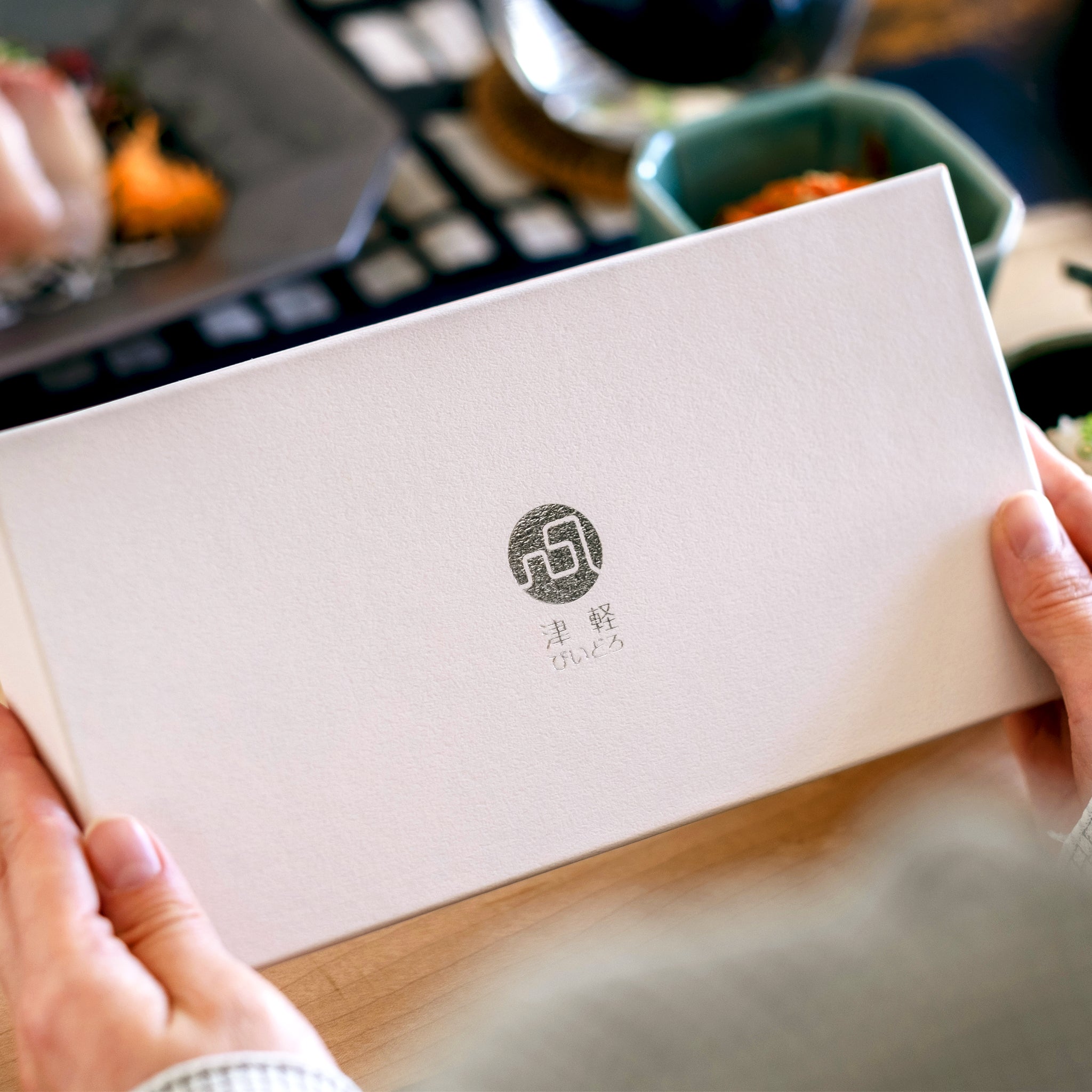 津軽びいどろ 豆皿ギフト りんご豆皿ペアセット 化粧箱を手で持ち上げている画像