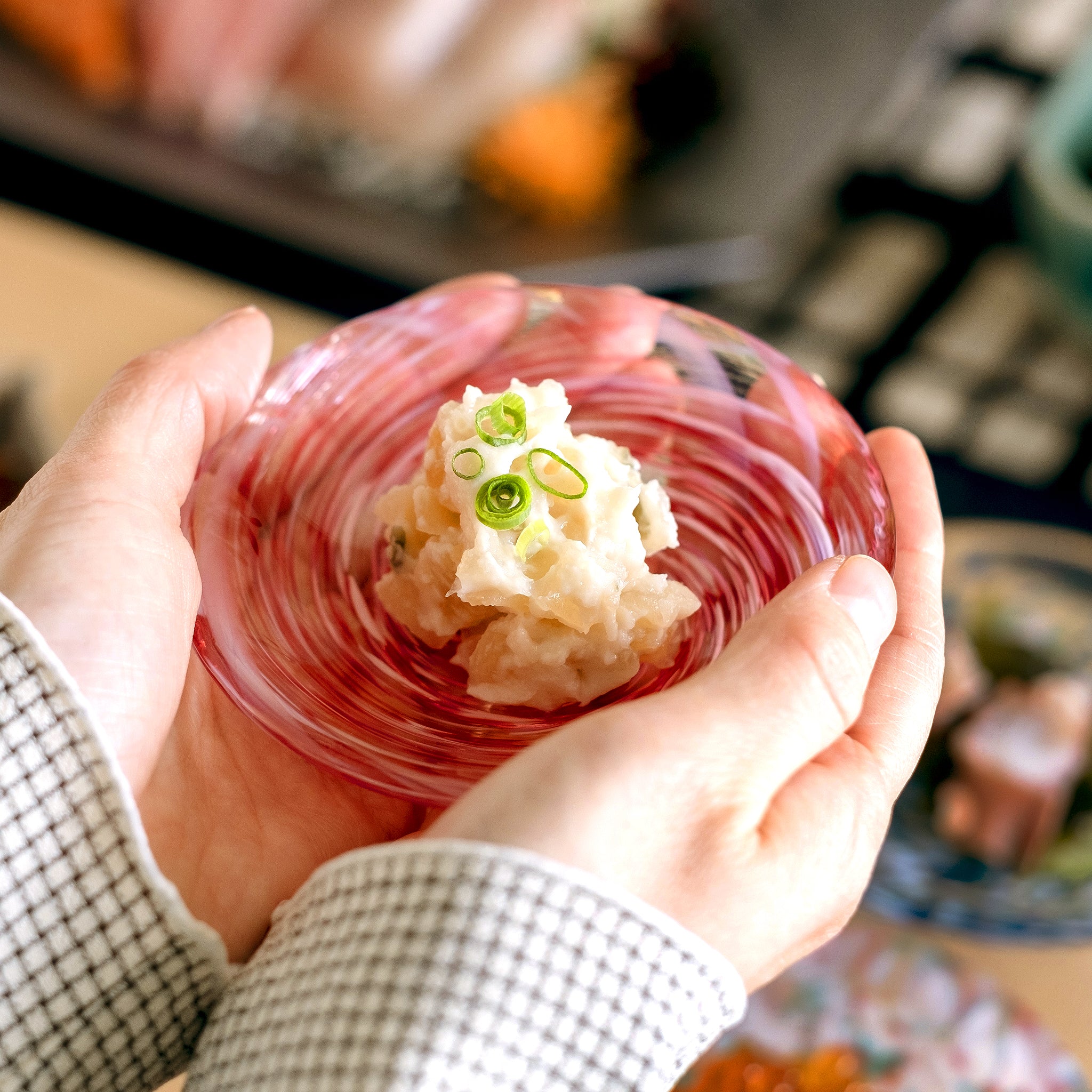 津軽びいどろ 豆皿ギフト 色色豆皿彩合わせセット ポテトサラダがよそわれたガラス食器を手で持ち上げている画像