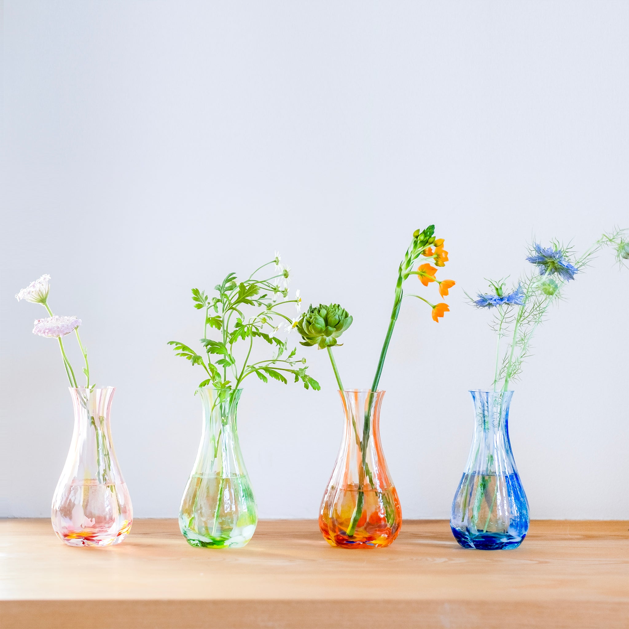 津軽びいどろ 花ひかり シーブルー 色違いの花器が横並びになっている画像