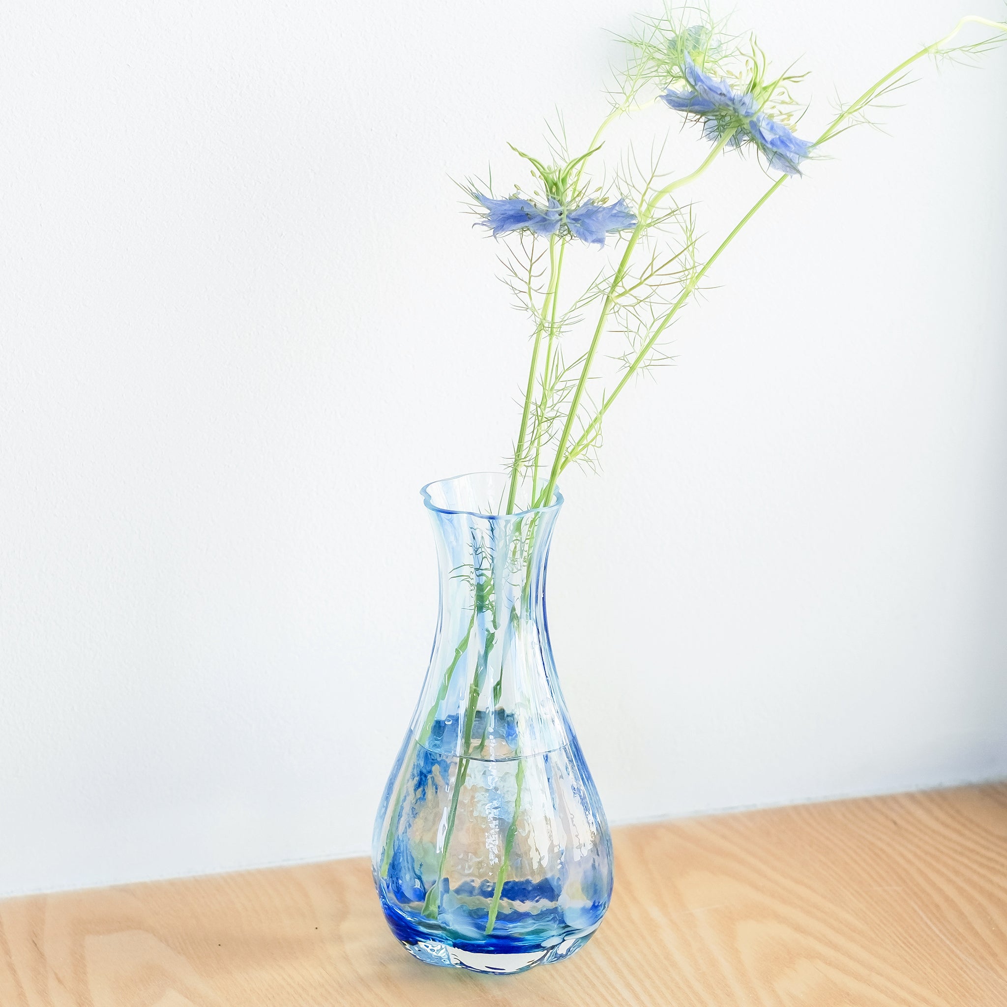 津軽びいどろ 花ひかり シーブルー 数本の切り花が活けられた花器の画像