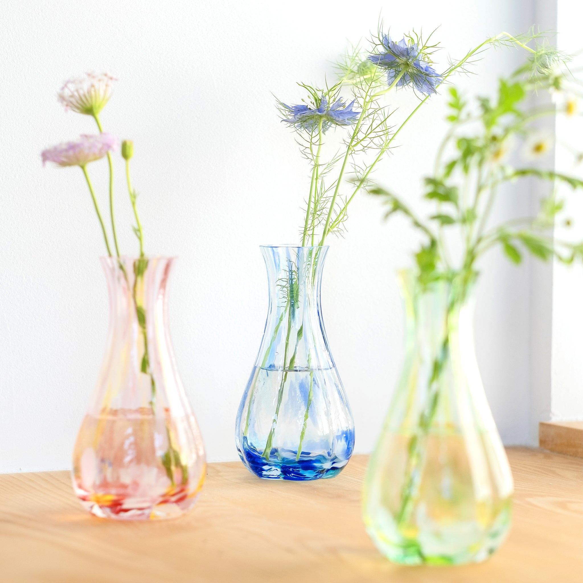 津軽びいどろ 花ひかり シーブルー 色違いの花器が並んでいる画像