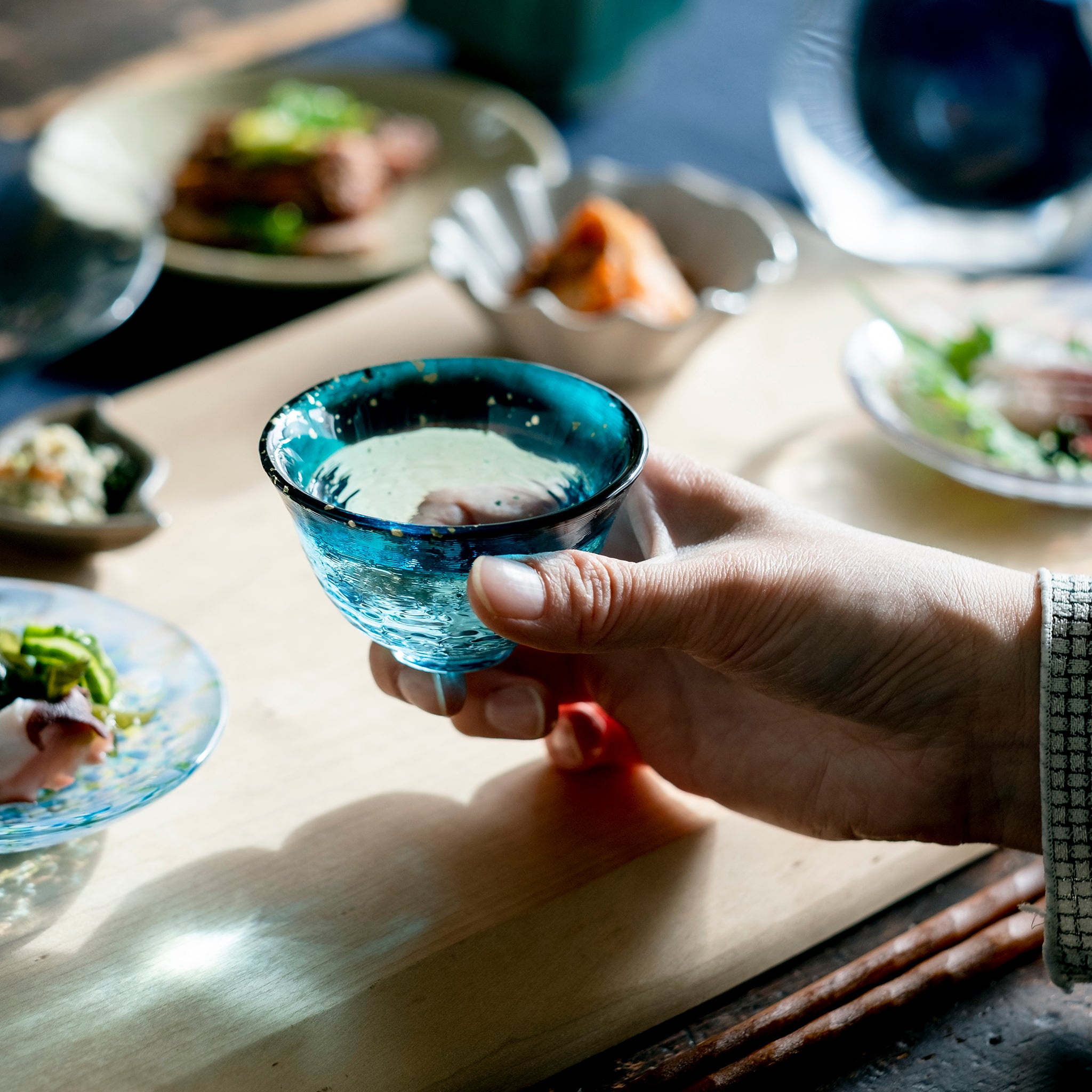 津軽びいどろ あおもりの海 盃 津軽海峡 盃を手で持ち上げている画像