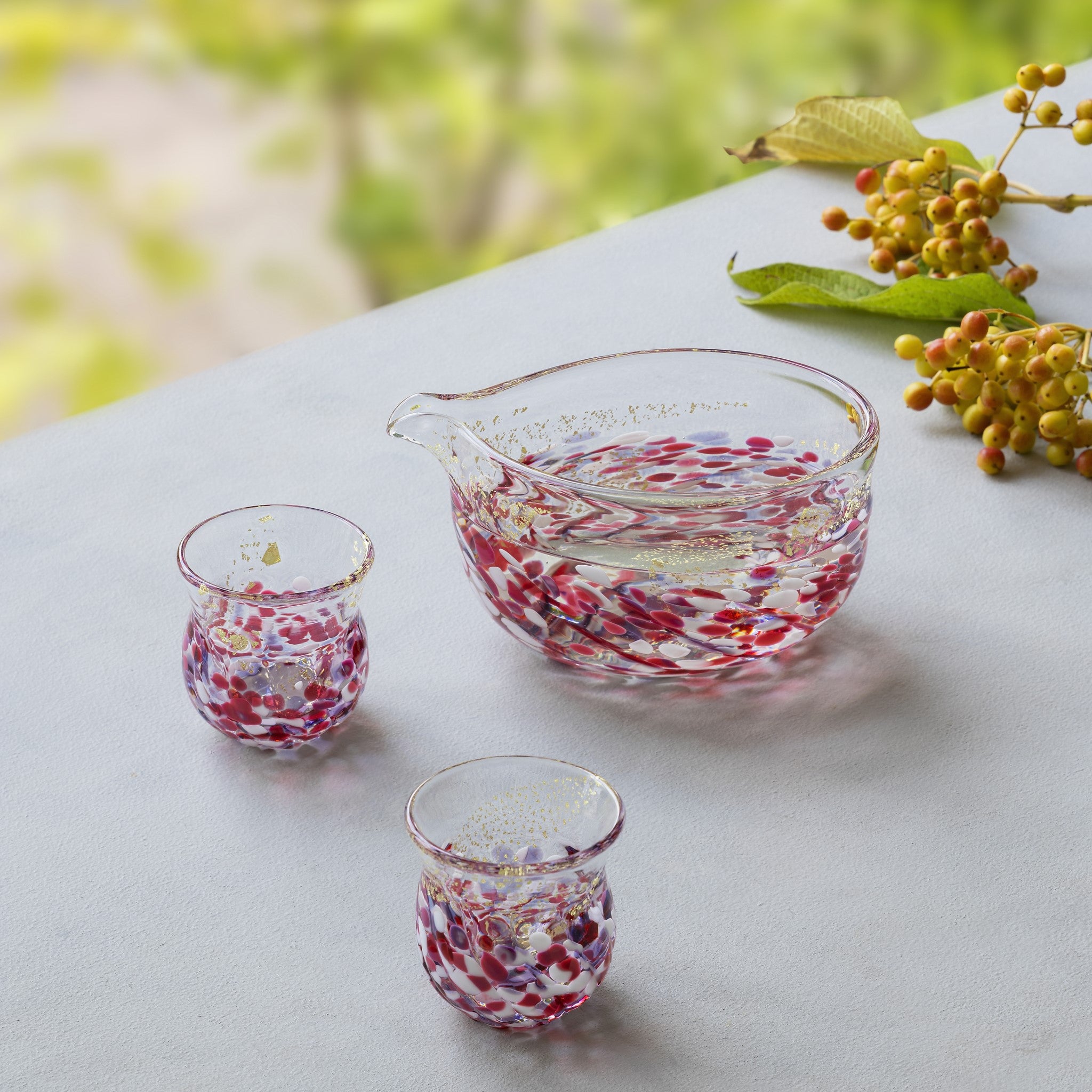 津軽びいどろ 花うつし 花筏酒器セット ピンク色の片口とおちょこがテーブルに並んでいる画像