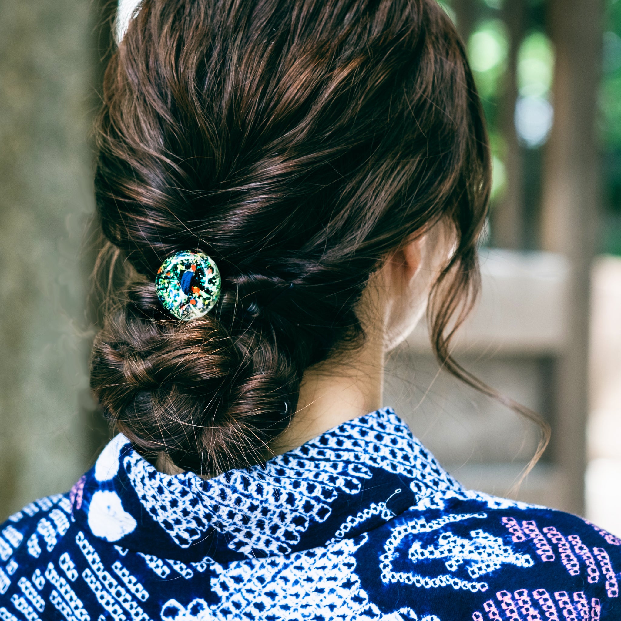 津軽びいどろ MATSURI まつり金彩ヘアゴム ヘアゴムで髪を結んでいる画像