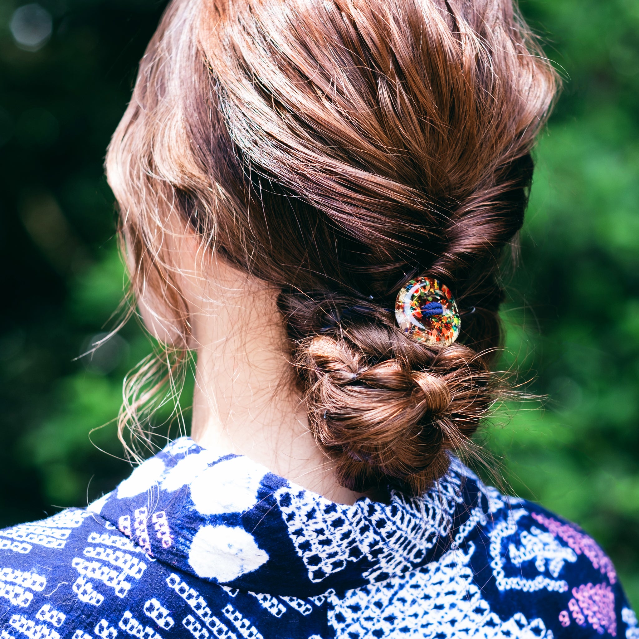  津軽びいどろ HANABI はなび金彩ヘアゴム ヘアゴムで髪を結んでいる画像