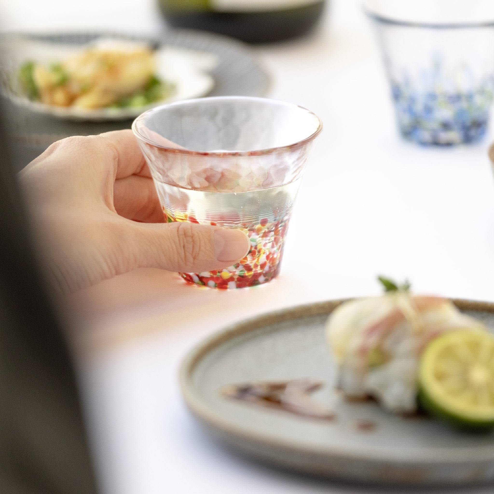 津軽びいどろオンラインショップ 津軽びいどろ にほんの色 ふうけい 盃 紅葉山 おちょこを手で持ち上げている画像