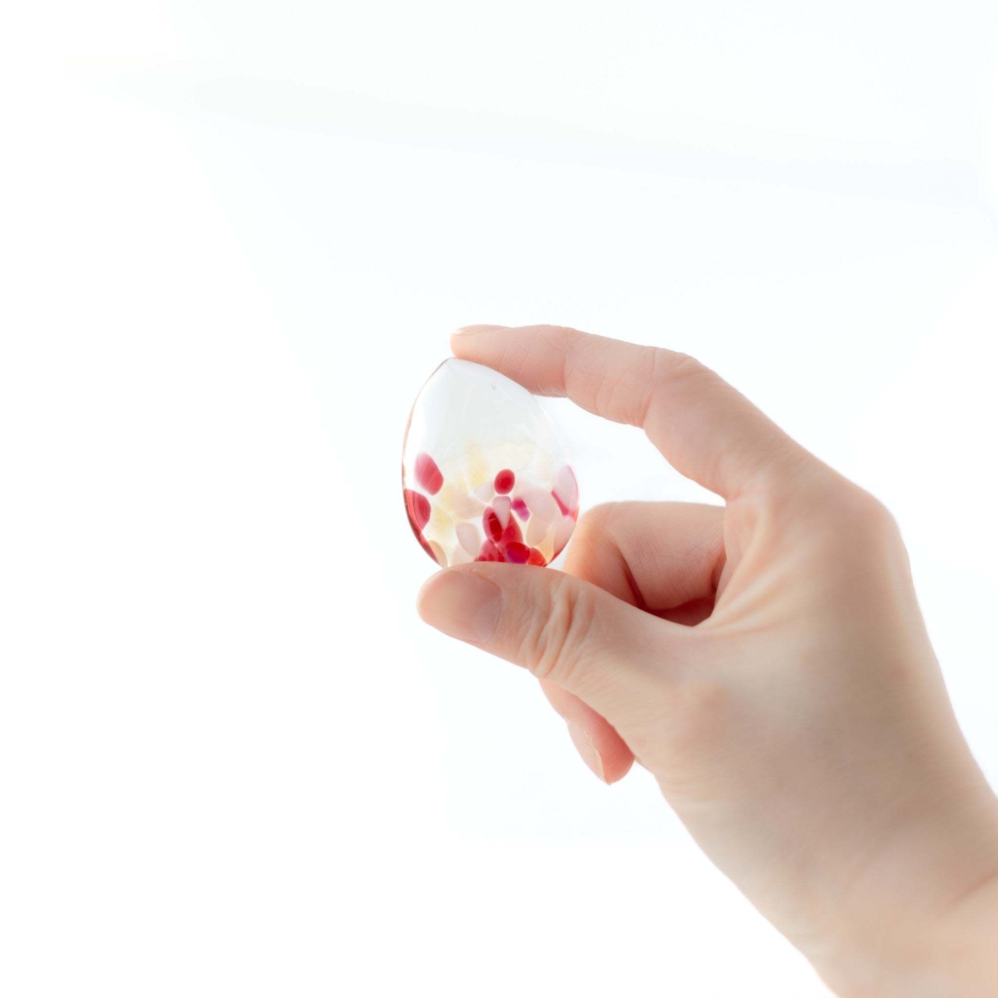 津軽びいどろ 津軽自然色りんご りんご箸置箸セット ガラスの箸置きを手でつかんでいる画像