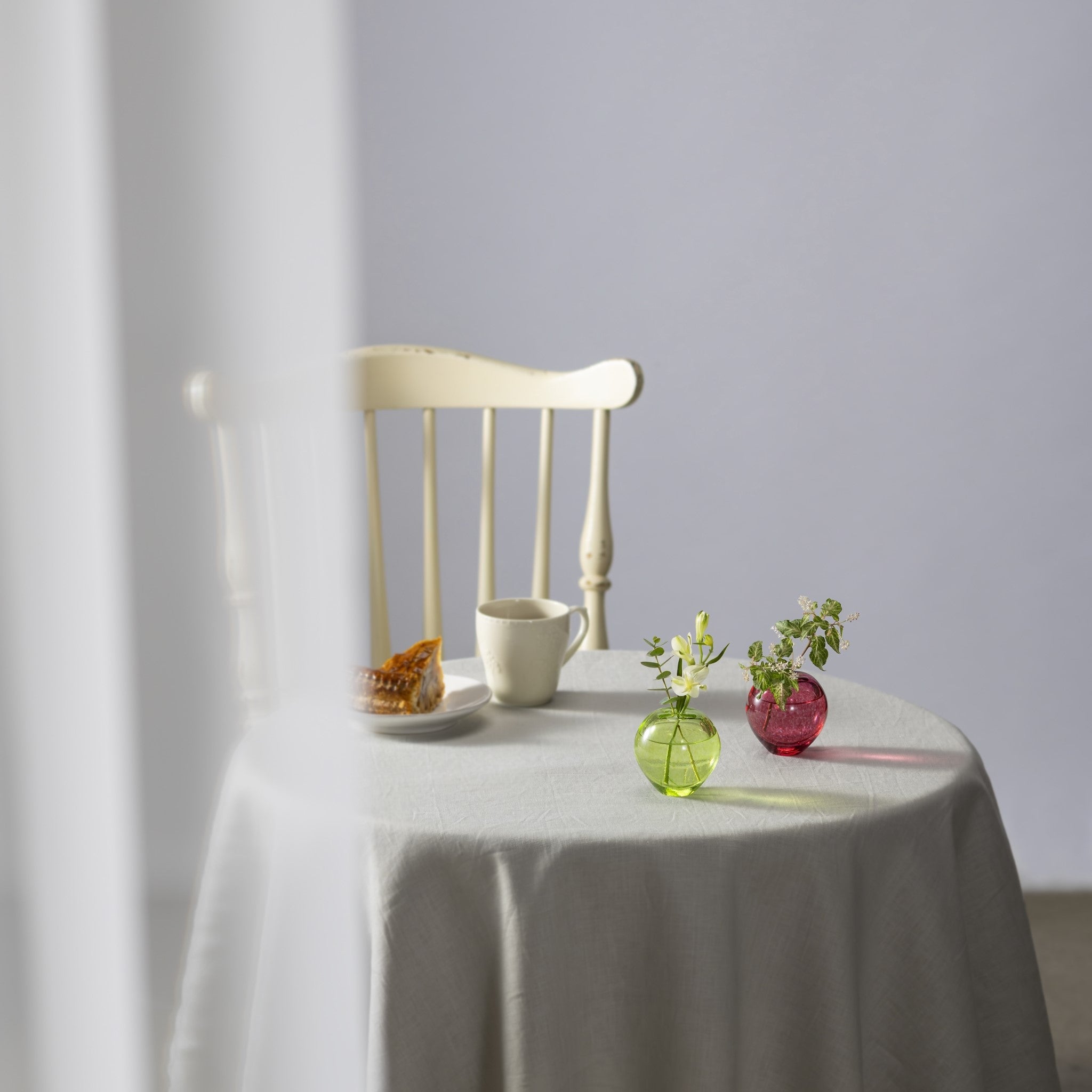 津軽びいどろ 津軽自然色りんご あおりんご一輪挿し テーブルにカラフルな花瓶が2つ並んでいる画像