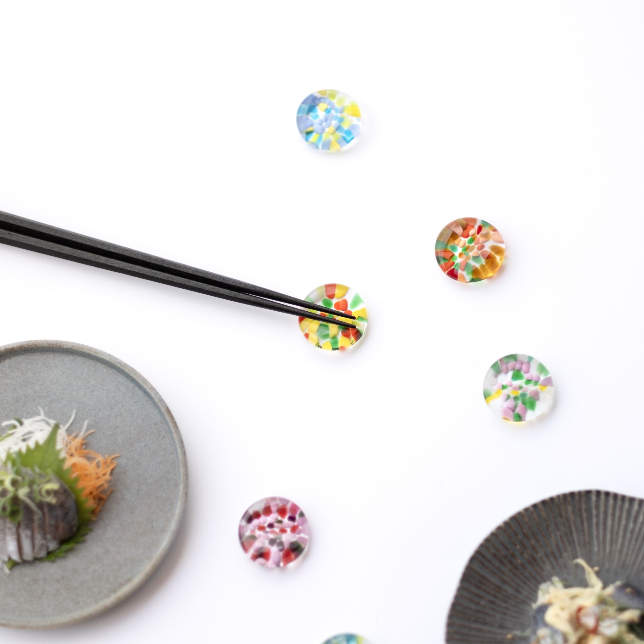 津軽びいどろ ⼗⼆花⽉ 箸置き 8月 ポピー カラフルな箸置きがテーブルに並んでいる画像