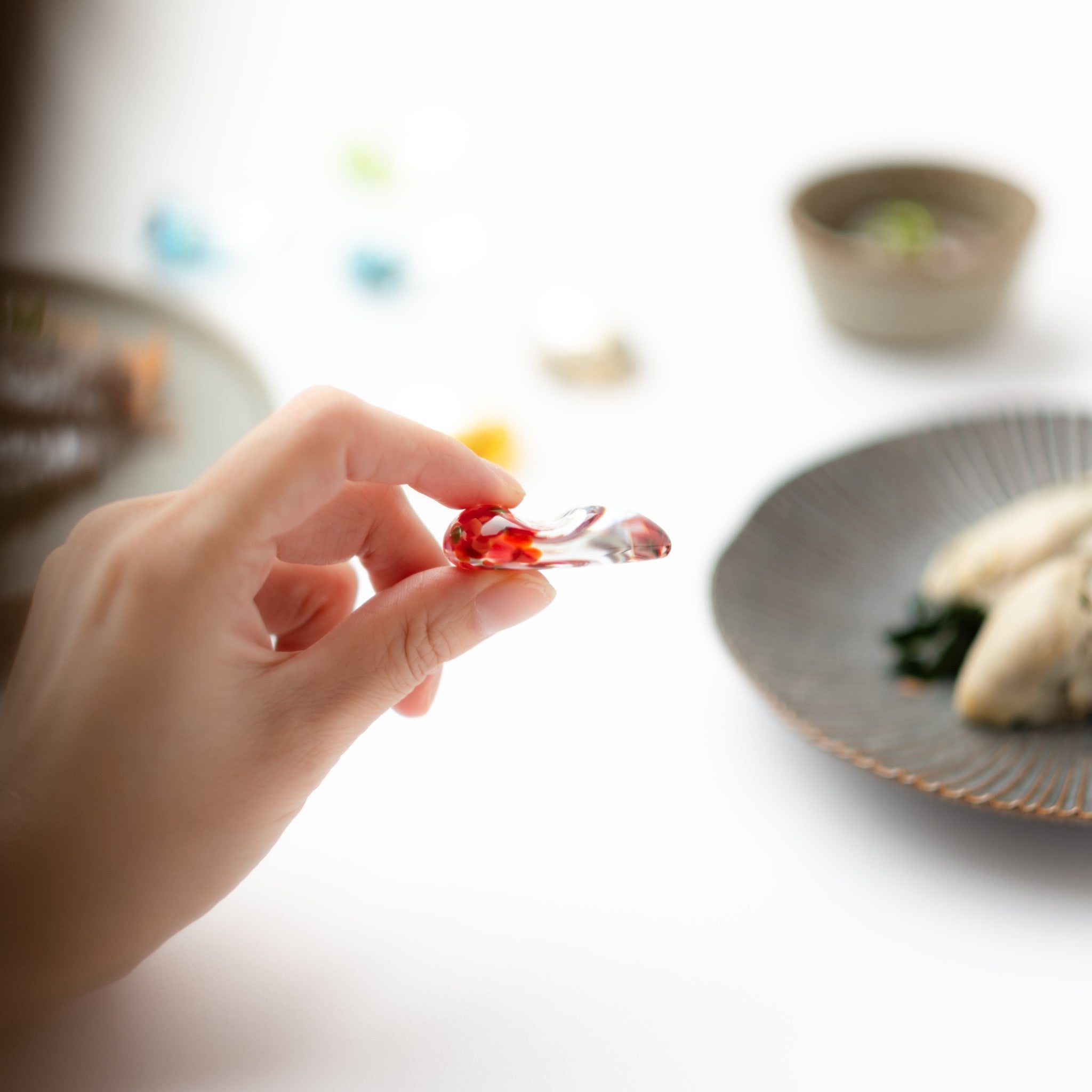 津軽びいどろ 白神の森響 箸置き アカショウビン ガラスの箸置きを手でつまんでいる画像