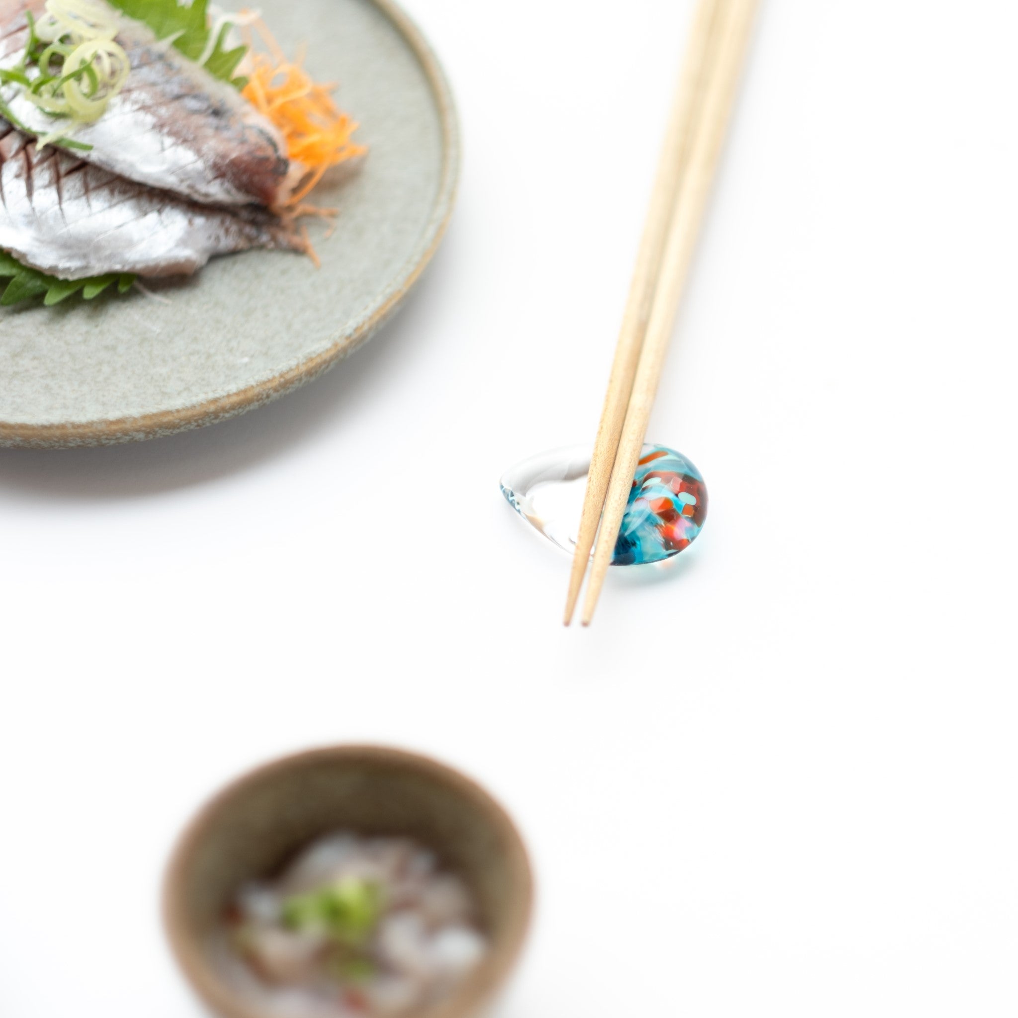 津軽びいどろ 白神の森響 箸置き カワセミ 水色の箸置きに箸がセットされている画像