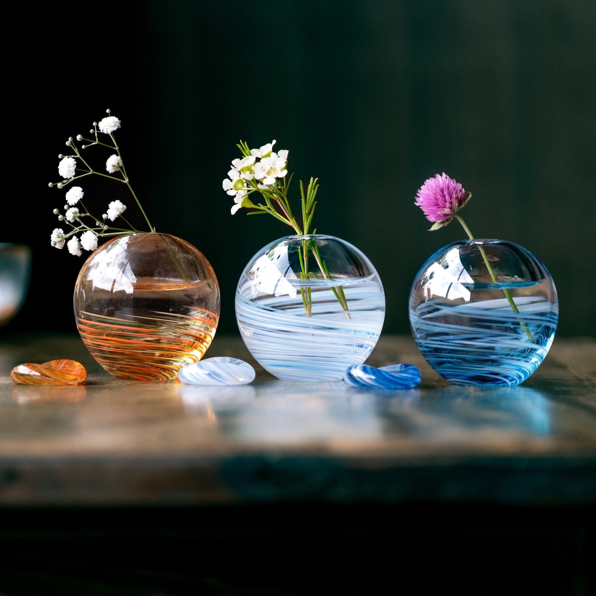 津軽びいどろ 六の色(むつのいろ) 一輪挿し 海 丸い一輪挿しがテーブルに並んでいる画像