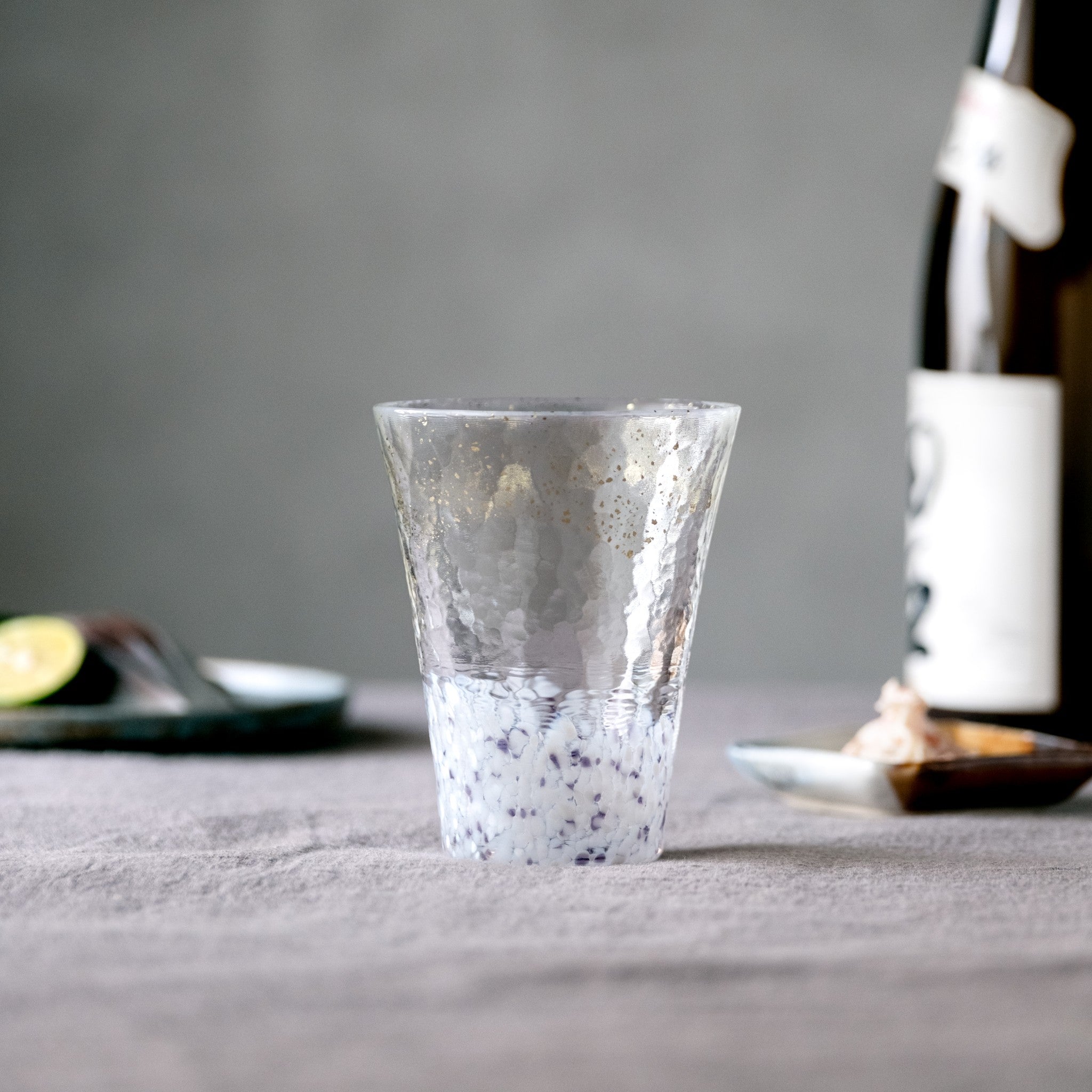 【販路限定】津軽びいどろ 雪うつし こな雪 グラス テーブルに置いている白いグラスの画像