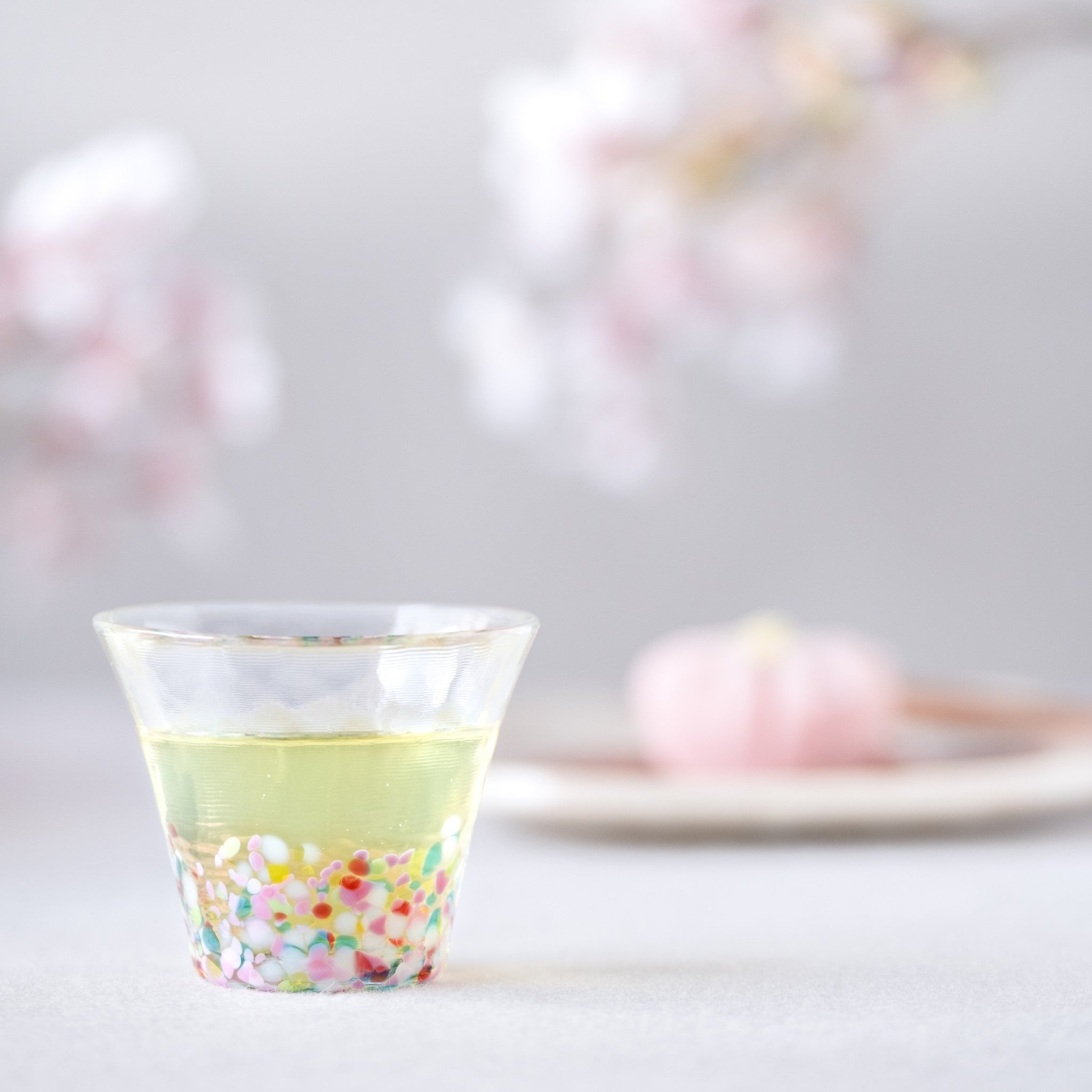 津軽びいどろ にほんの色 ふうけい 盃 春の丘 緑茶が注がれたおちょこ